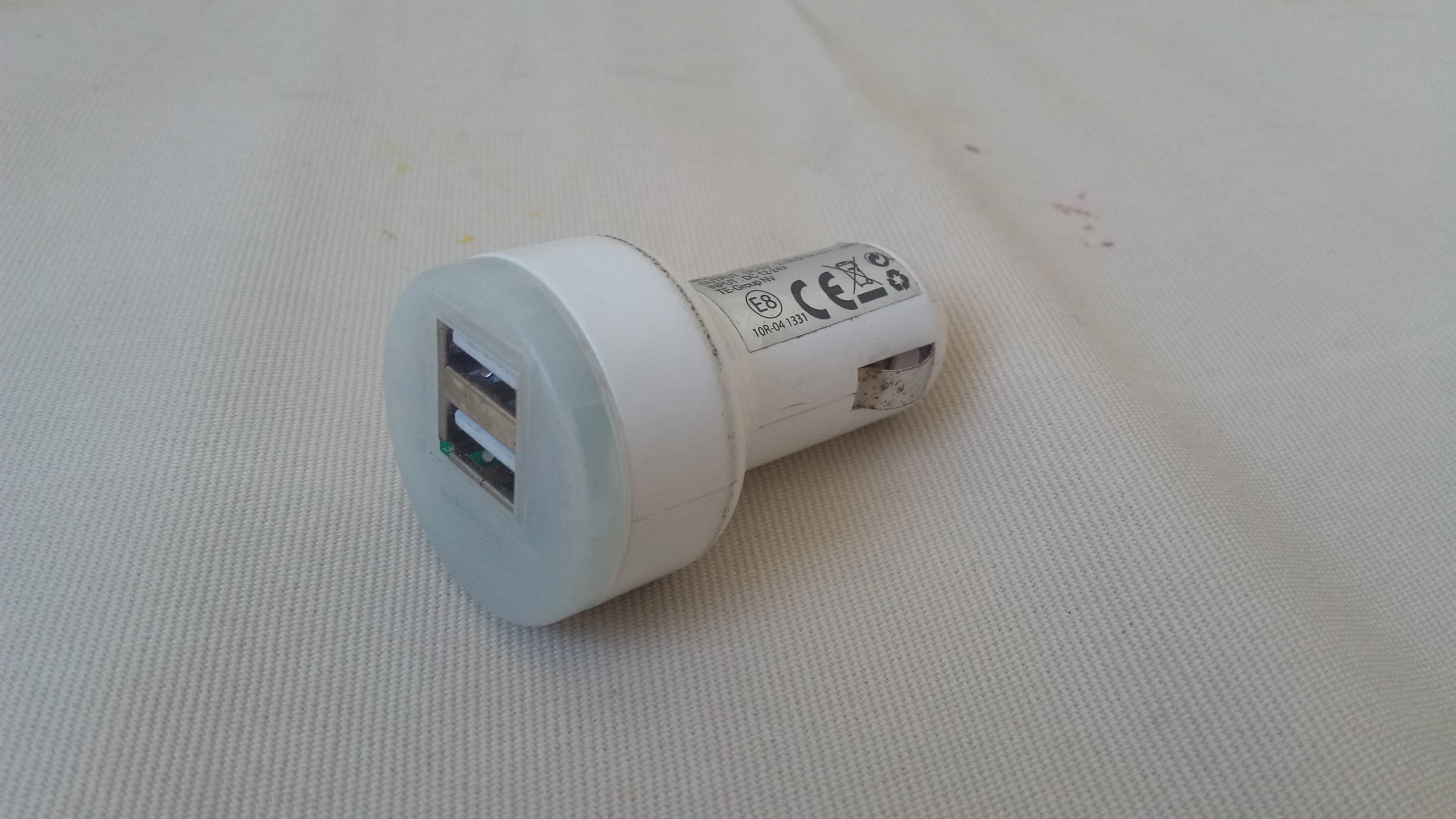 A compact dual-port USB car charger in a 12-volt socket, the everyday adapter type this guide rates