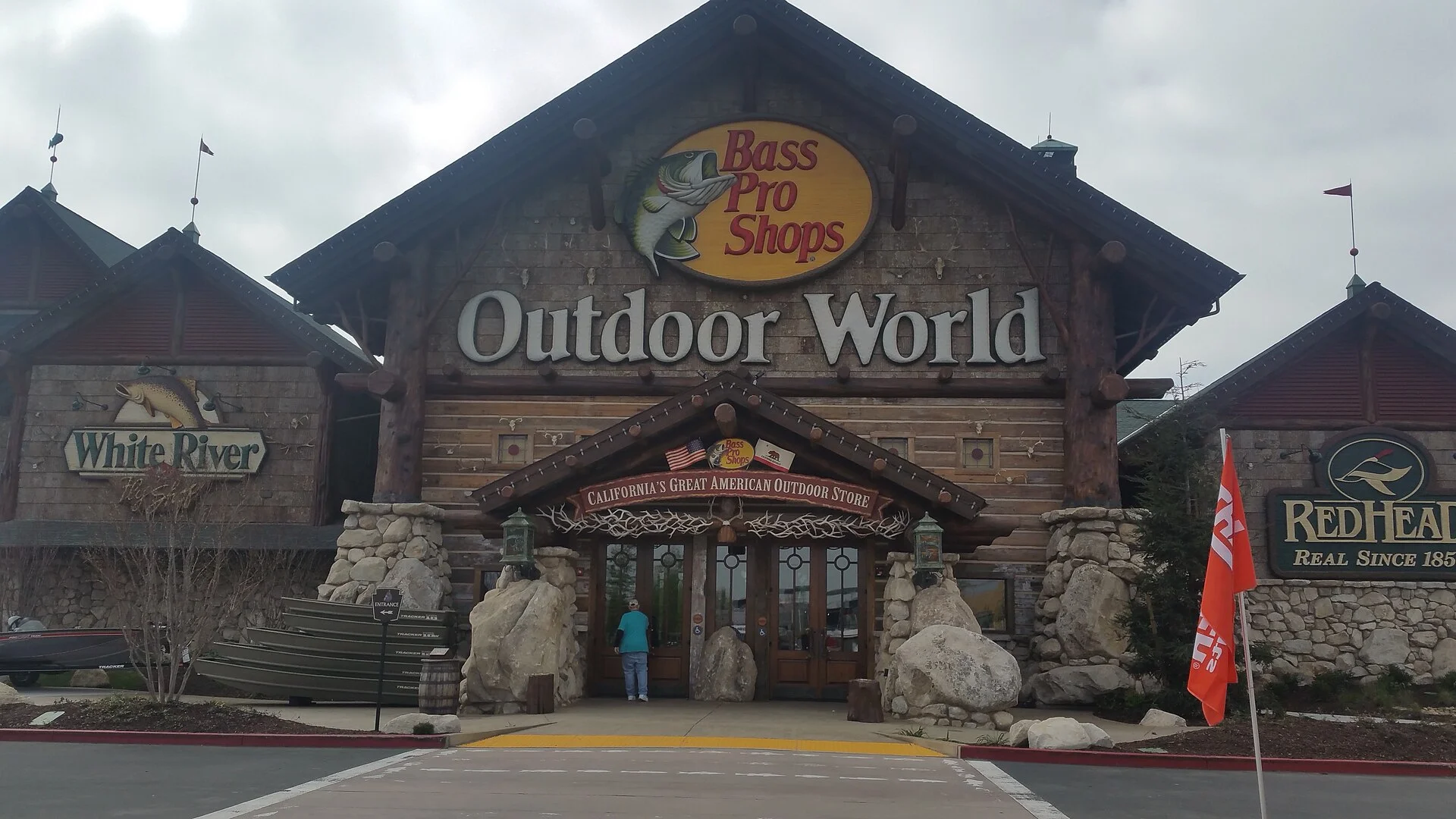 A Bass Pro Shops Outdoor World storefront and parking lot