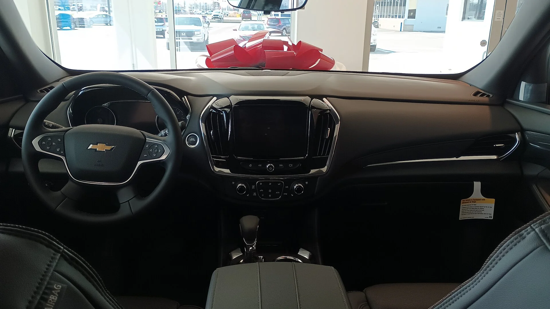 Chevy Traverse interior — the dashboard, steering wheel and center console (where the 12V outlets sit) of a 2023 Traverse