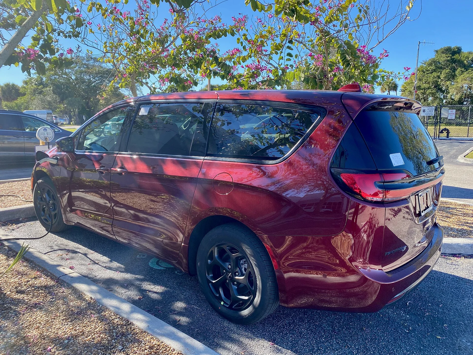 2023 Chrysler Pacifica Hybrid minivan in Velvet Red Pearl Coat charging 1of2