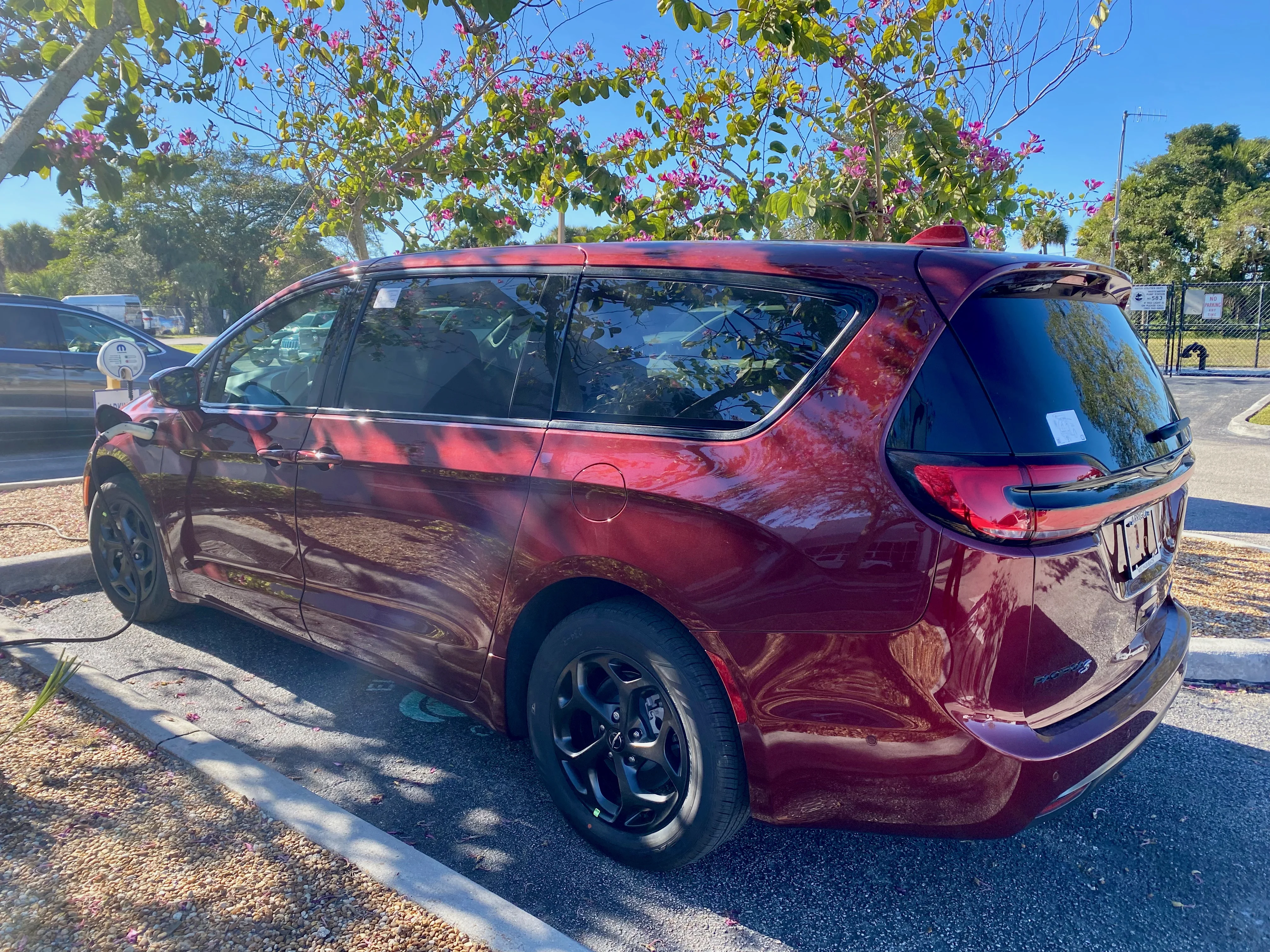 2023 Chrysler Pacifica Hybrid minivan in Velvet Red Pearl Coat charging 1of2
