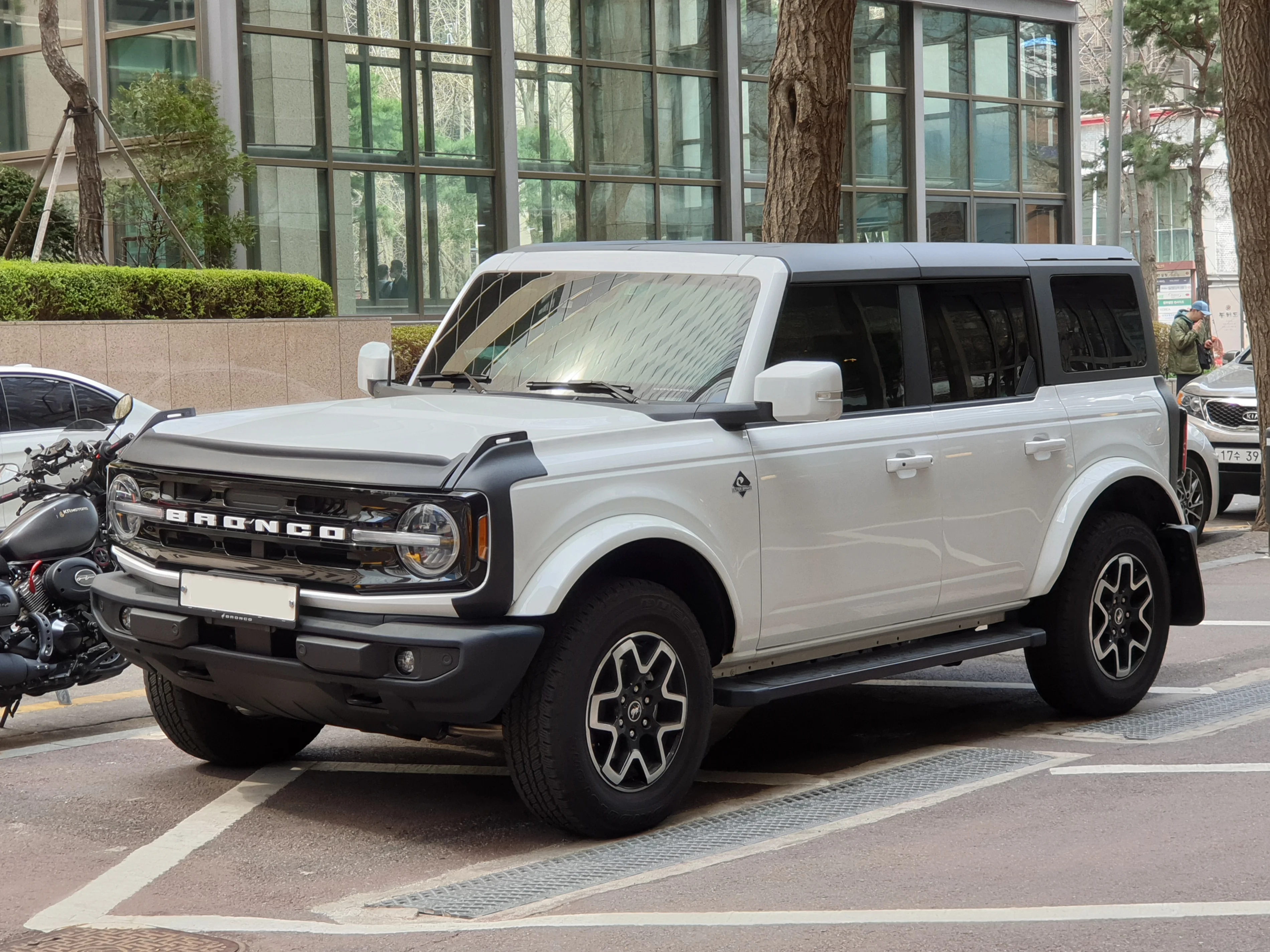 White four-door Ford Bronco SUV, current generation, parked kerbside in a front three-quarter view.