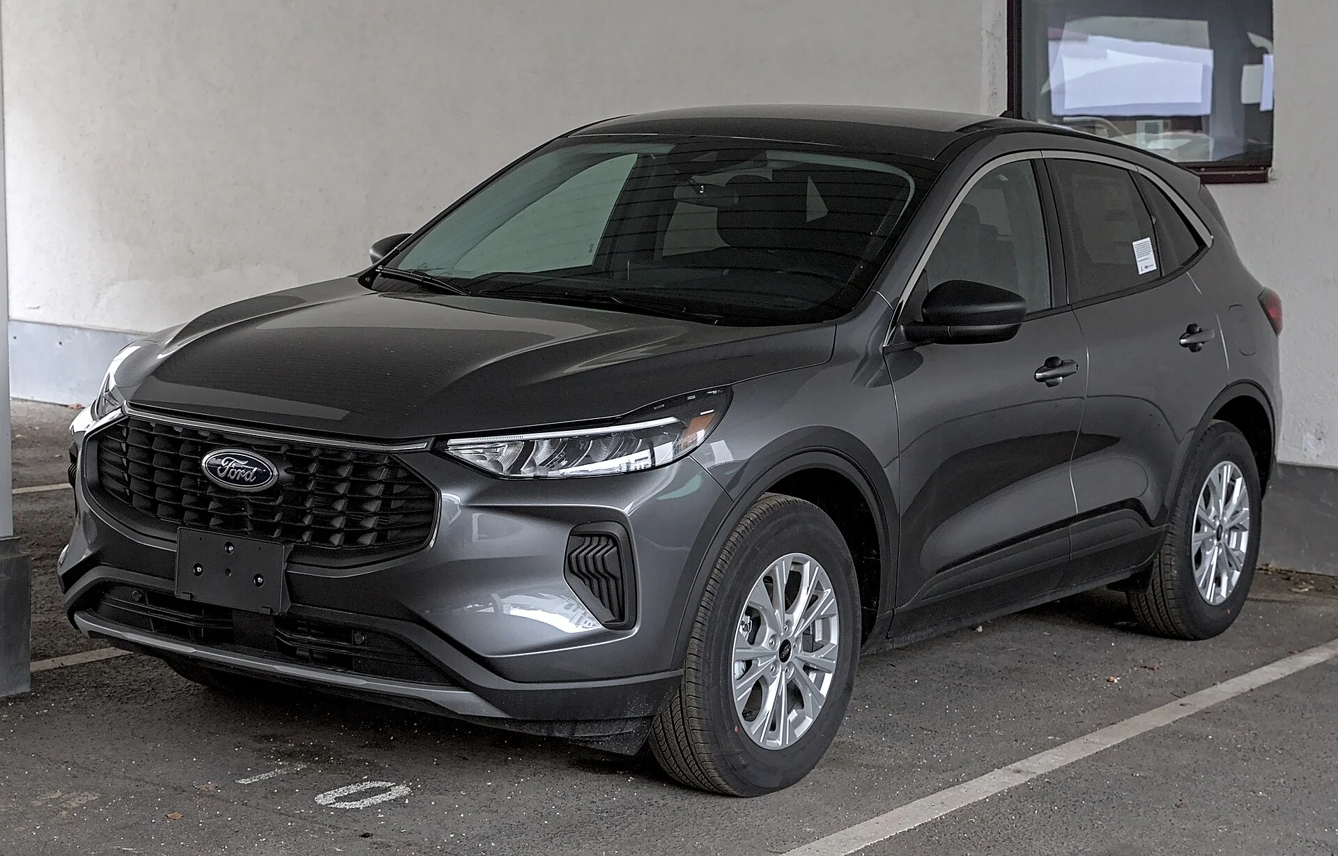 Ford Escape — a grey 2023 Escape, rear three-quarter view (the cargo area a sleeping platform is built in)