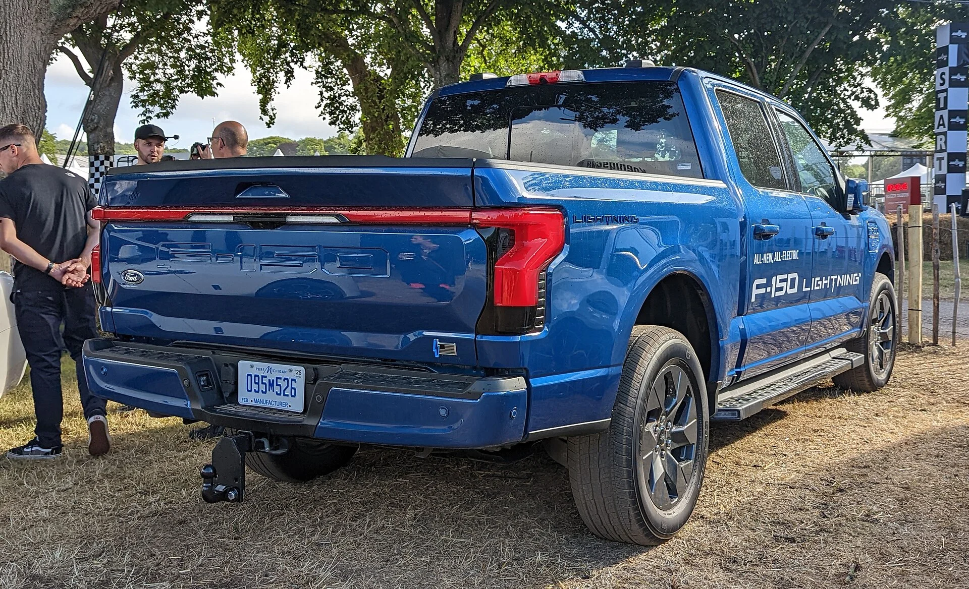 Ford F-150 Lightning — a blue 2022 Lightning, rear three-quarter view outdoors