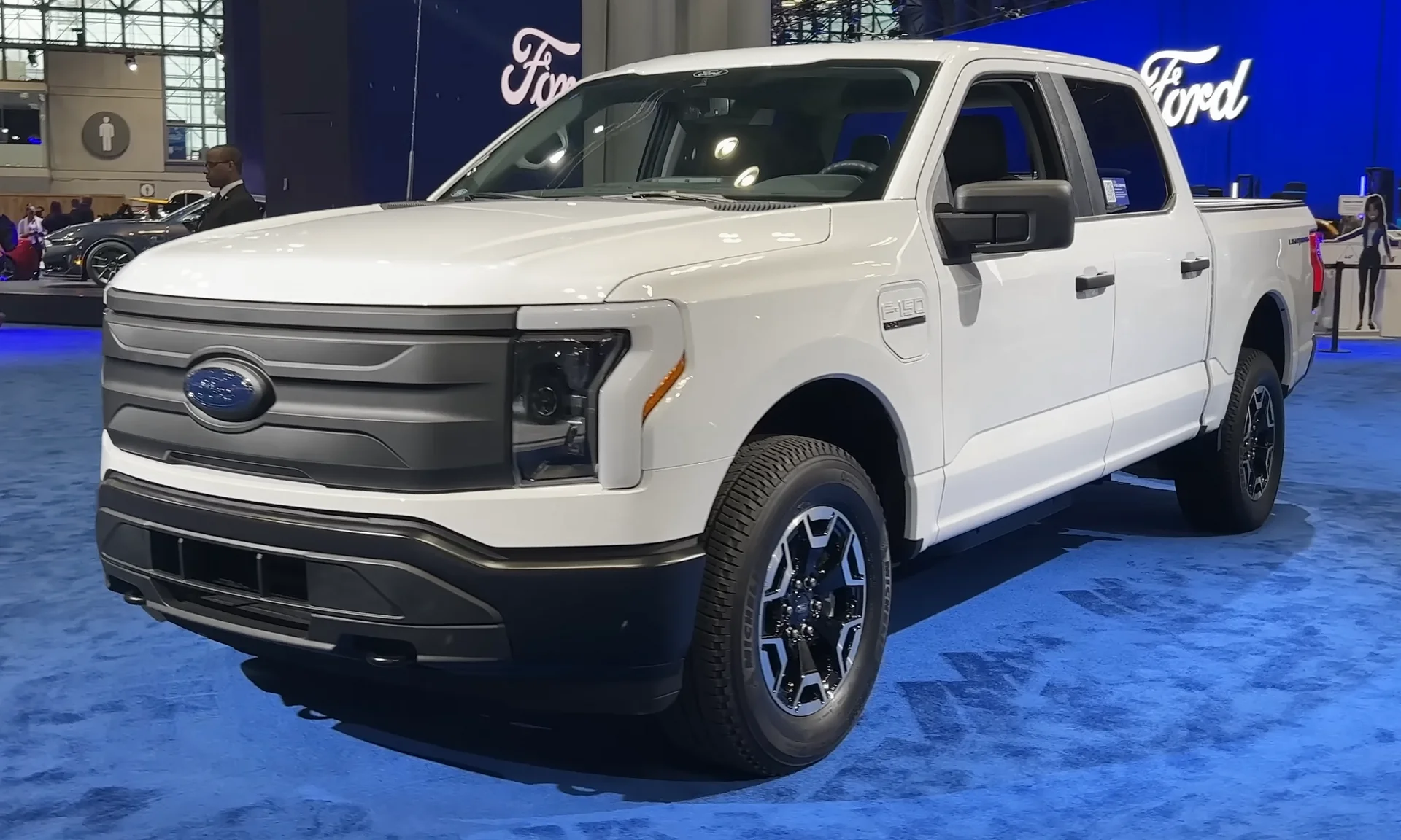 White Ford F-150 Lightning Pro electric pickup, front three-quarter view in a parking lot