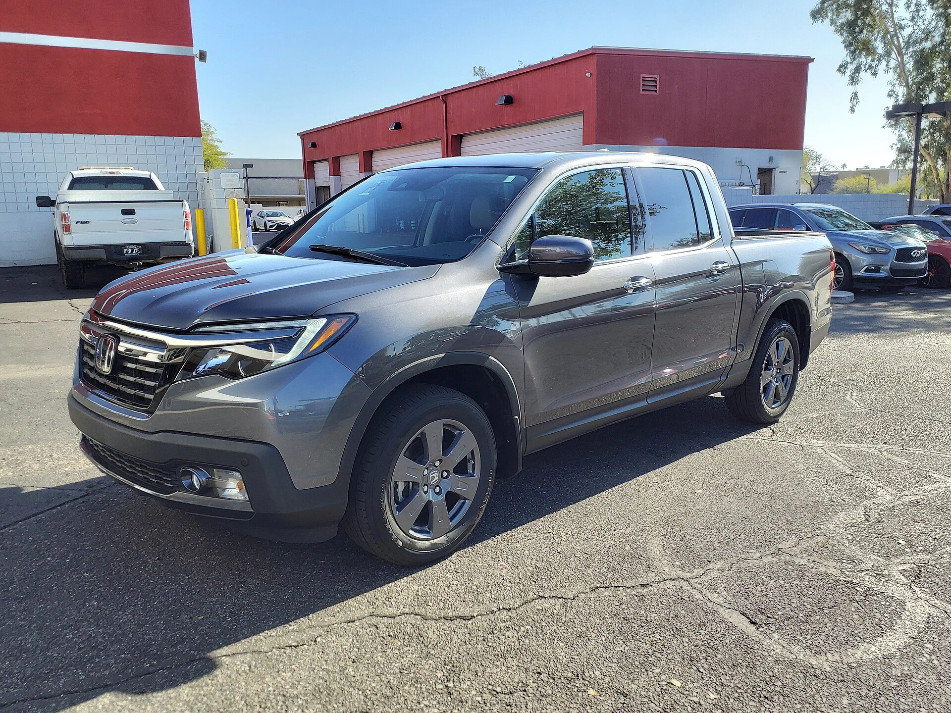 Grey Honda Ridgeline RTL-E crew-cab pickup, second generation, front three-quarter view in a sunny parking lot.