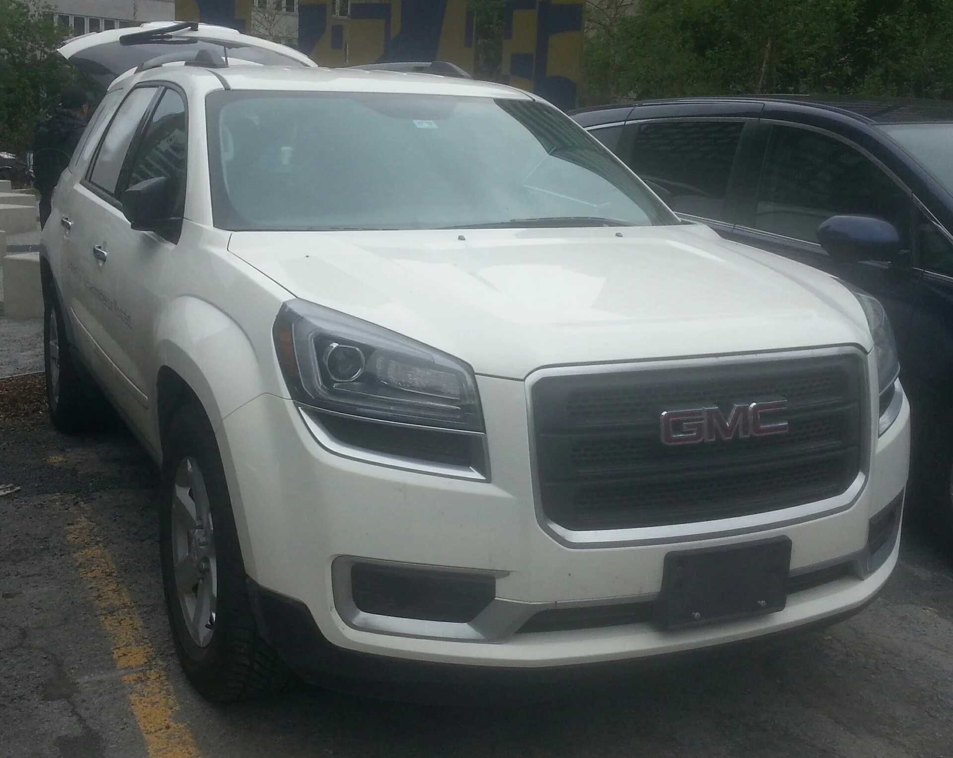 A GMC Acadia in white, the three-row family hauler used here for sleeping and storage