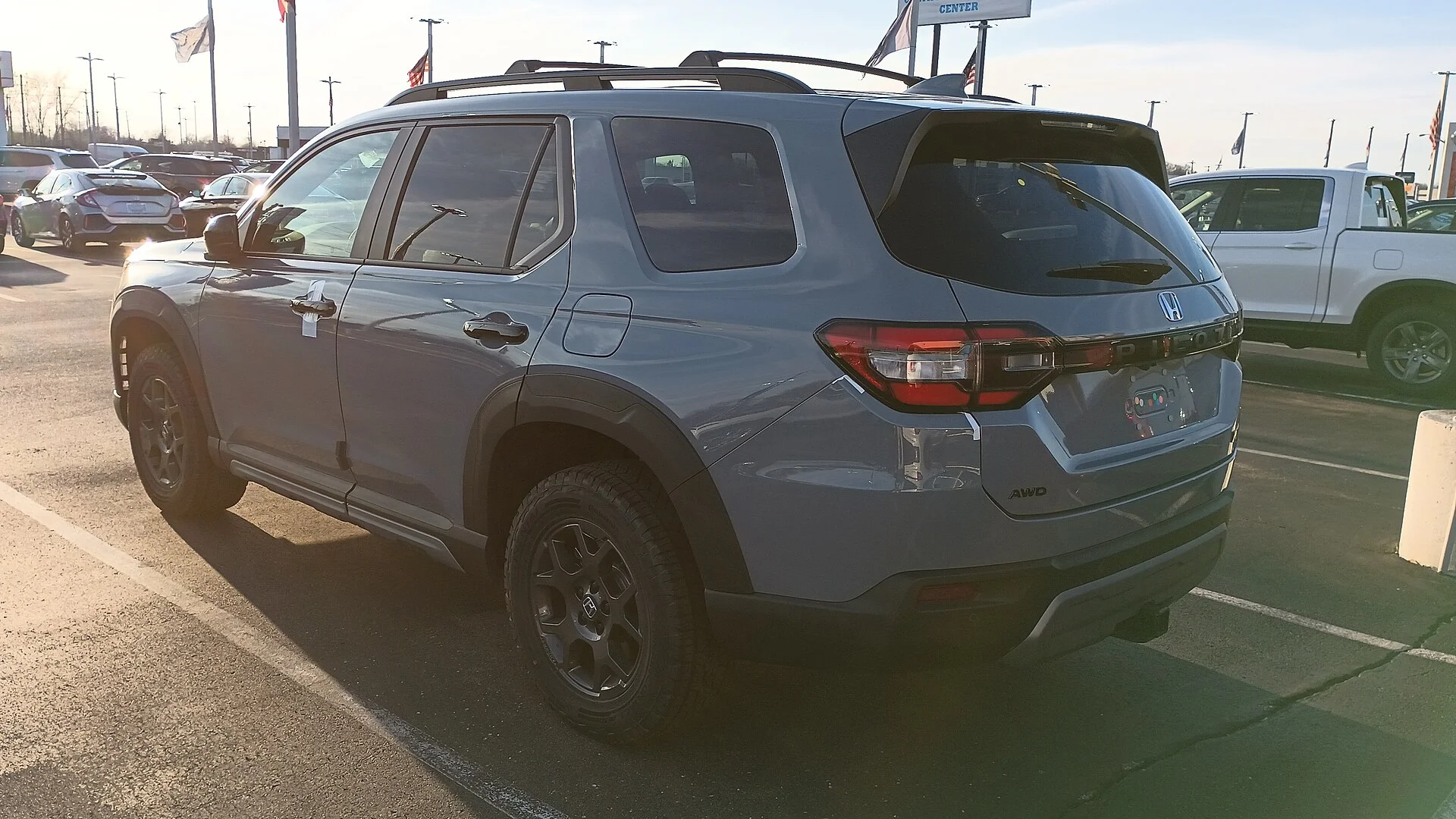 Honda Pilot — a grey 2023 Pilot, rear three-quarter view (the spare tire mounts under the rear cargo floor)