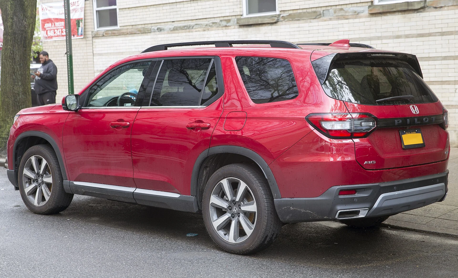Honda Pilot Touring — a red 2023 Pilot, side and rear three-quarter view