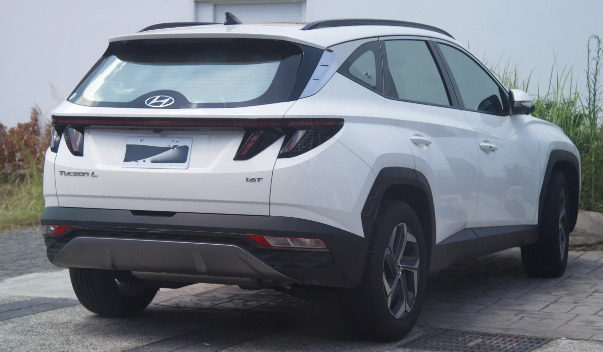 A Hyundai Tucson (NX4) rear three-quarter, the compact SUV whose 72-74 inch folded floor decides the sleeping fit