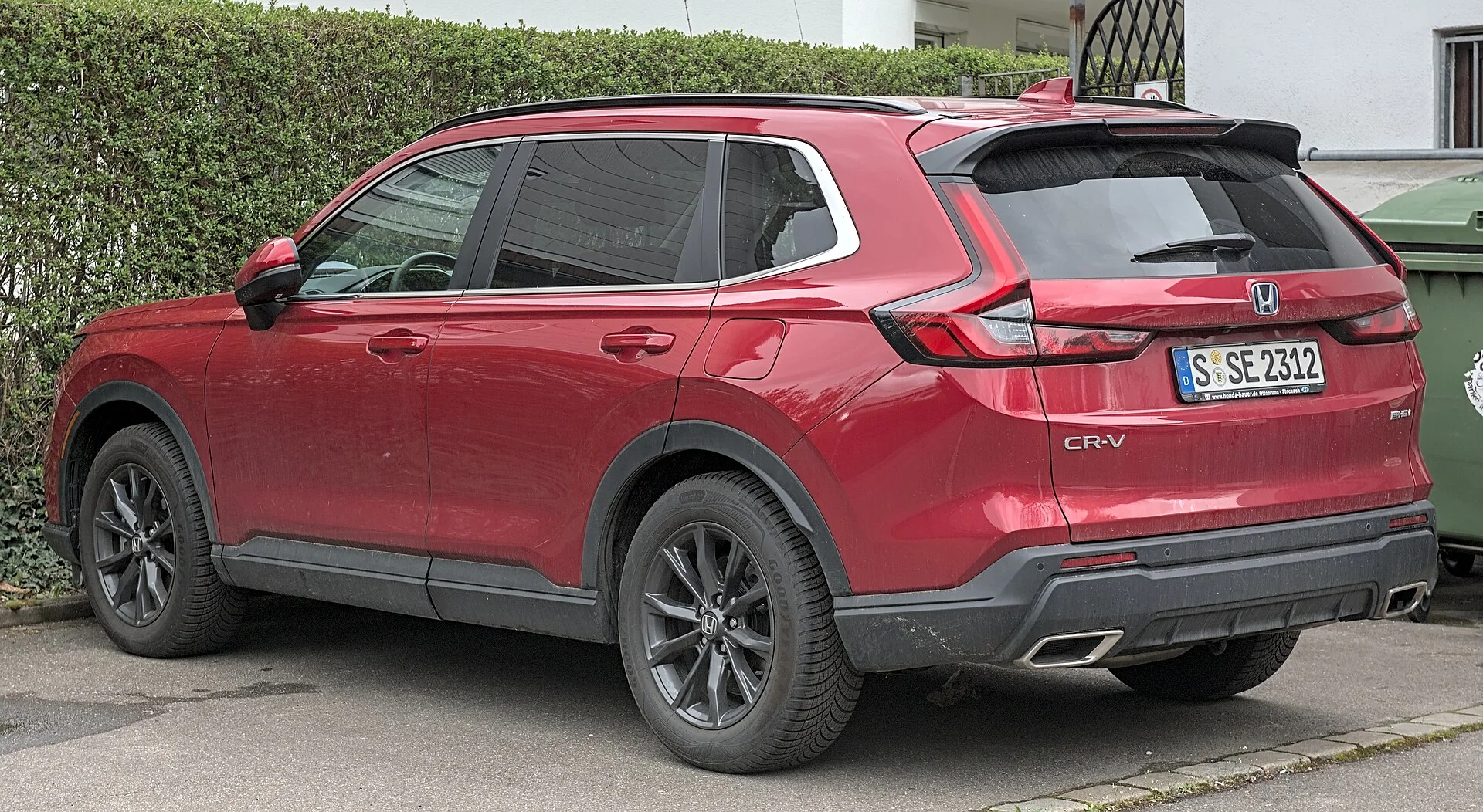 Red Honda CR-V hybrid, sixth generation, rear three-quarter view