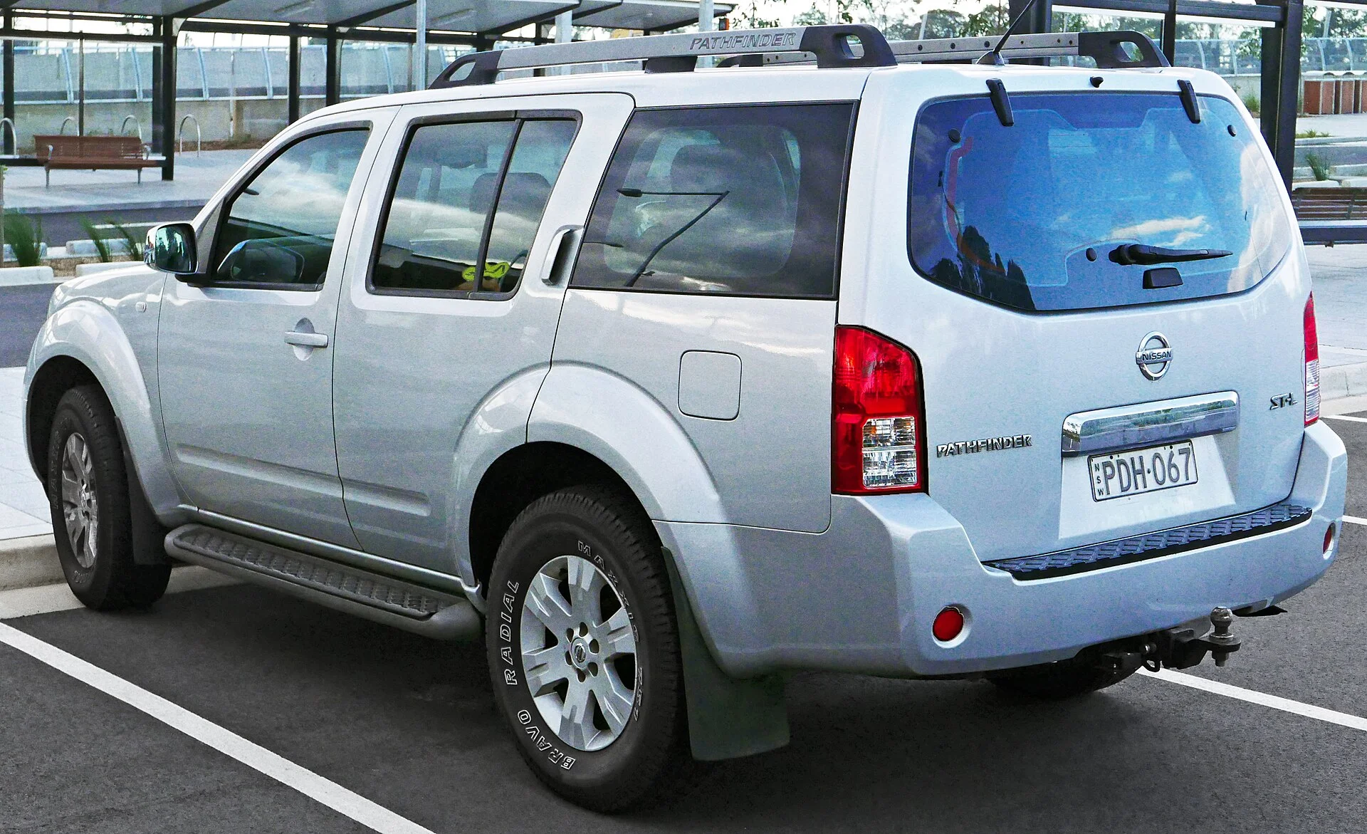 Silver Nissan Pathfinder SUV with a roof rack, rear three-quarter view showing the PATHFINDER tailgate lettering and Nissan badge