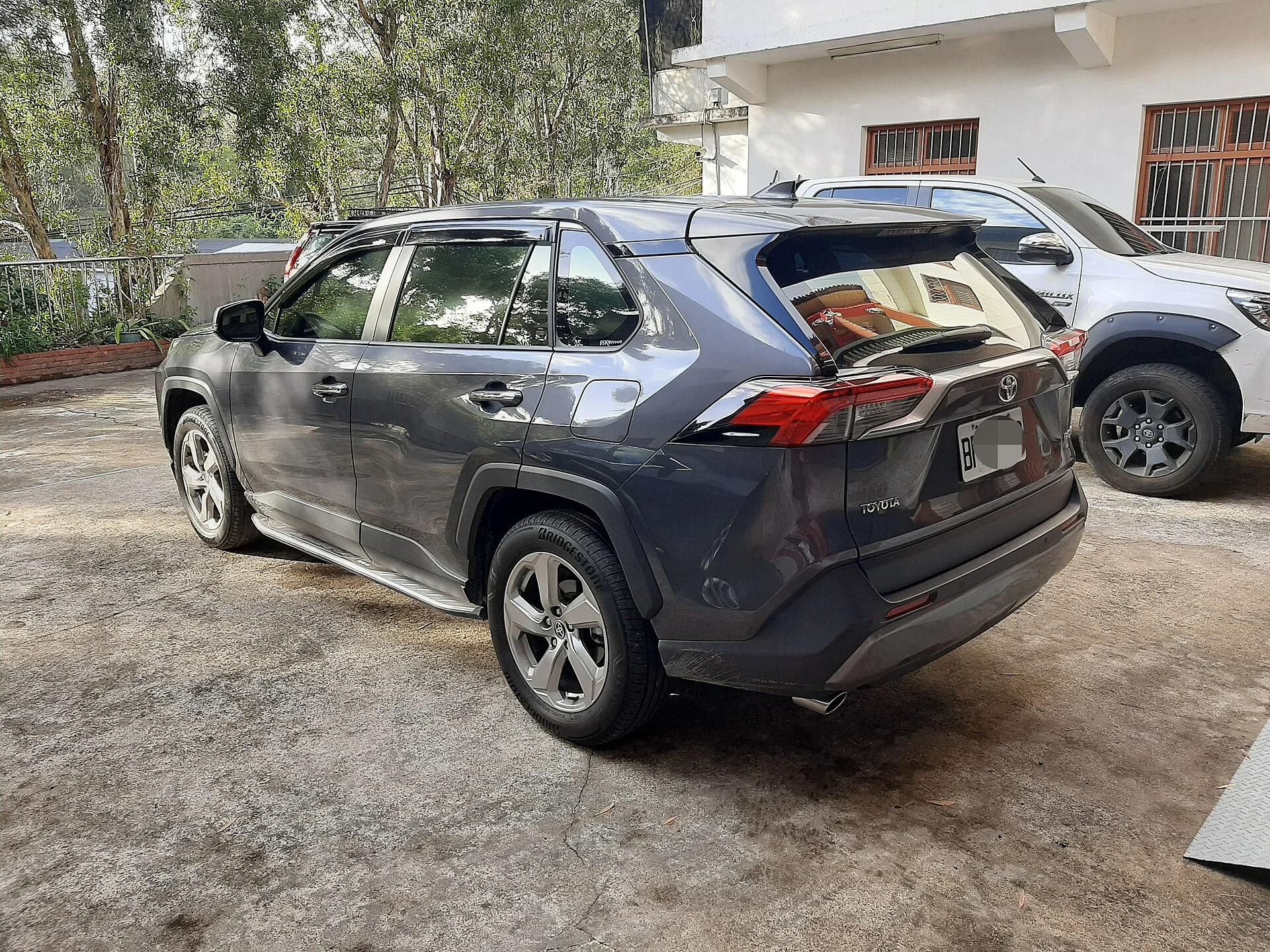 Grey Toyota RAV4, current generation, rear three-quarter view