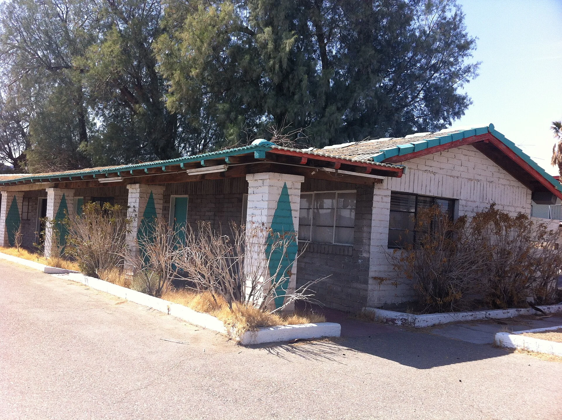 A roadside motel building beside its parking lot