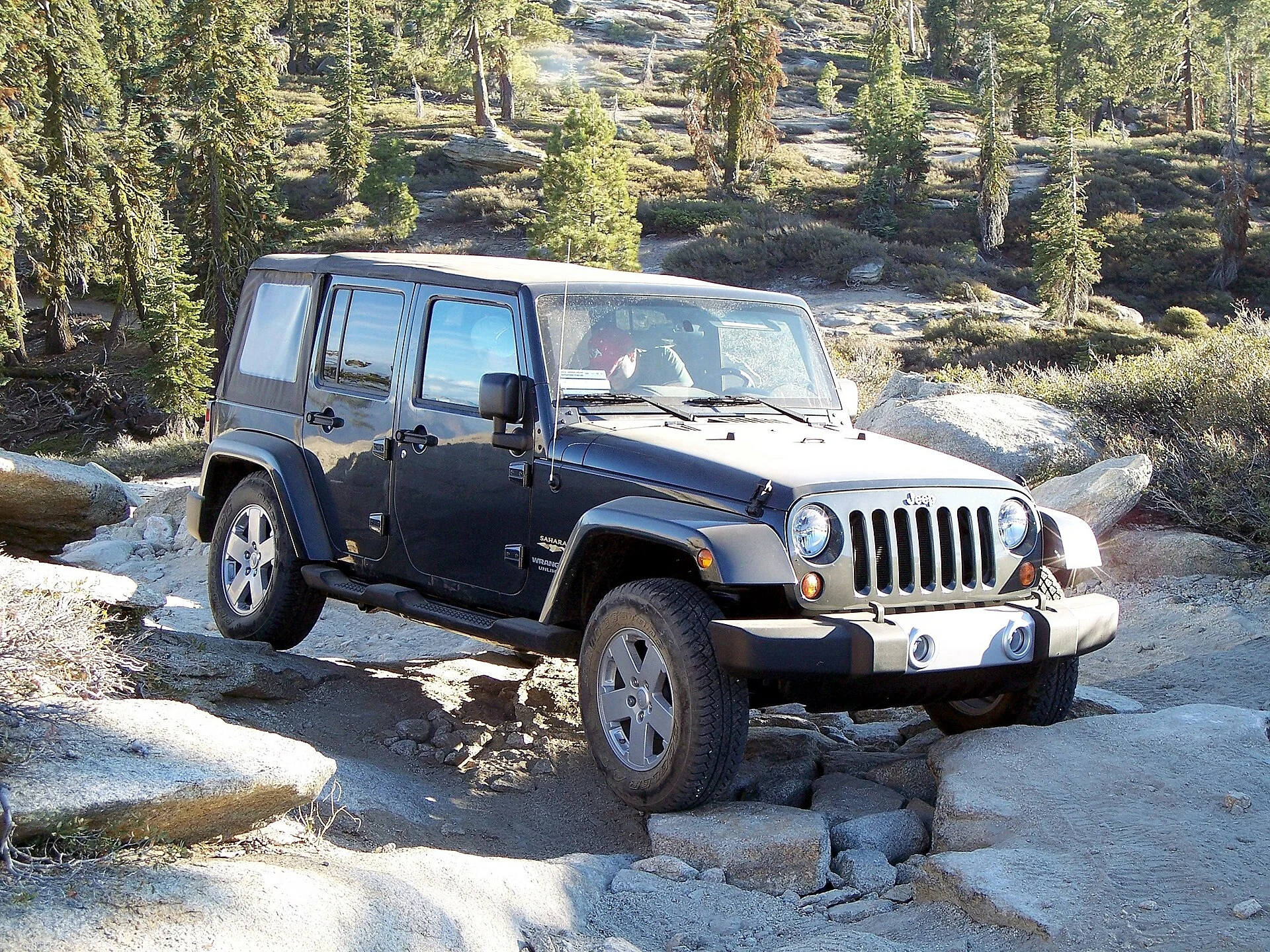A black Jeep Wrangler on a rocky trail