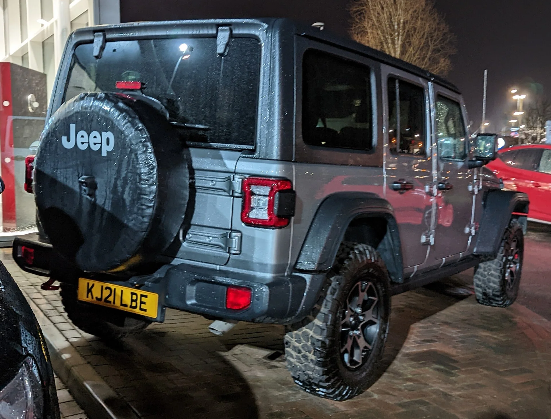 Grey Jeep Wrangler Rubicon rear view with the tailgate-mounted spare tire