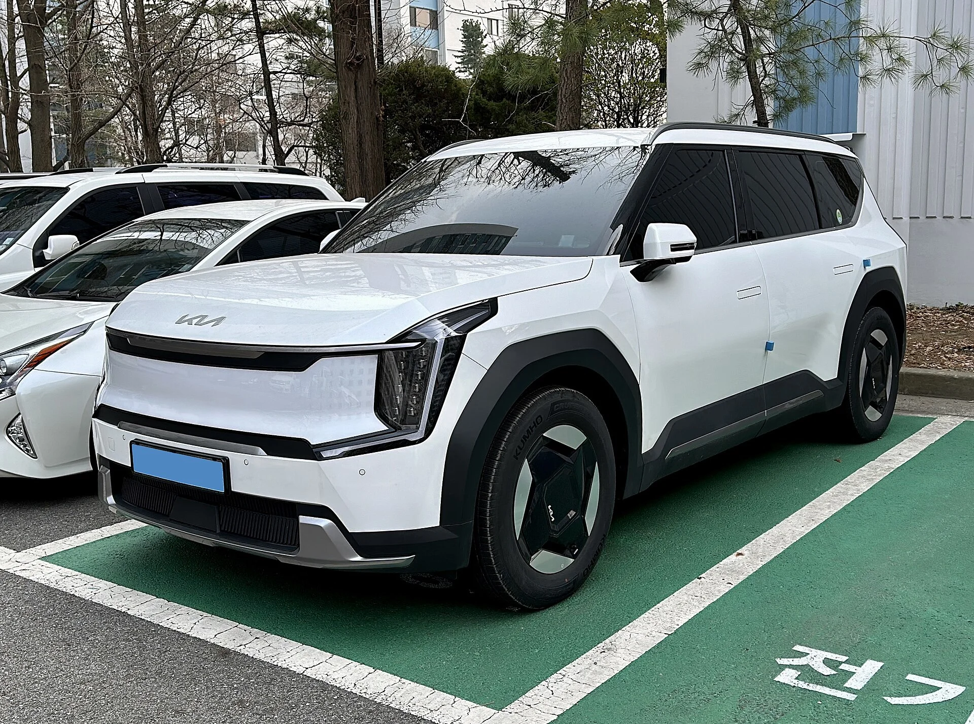 White Kia EV9 at an electric-vehicle charging station