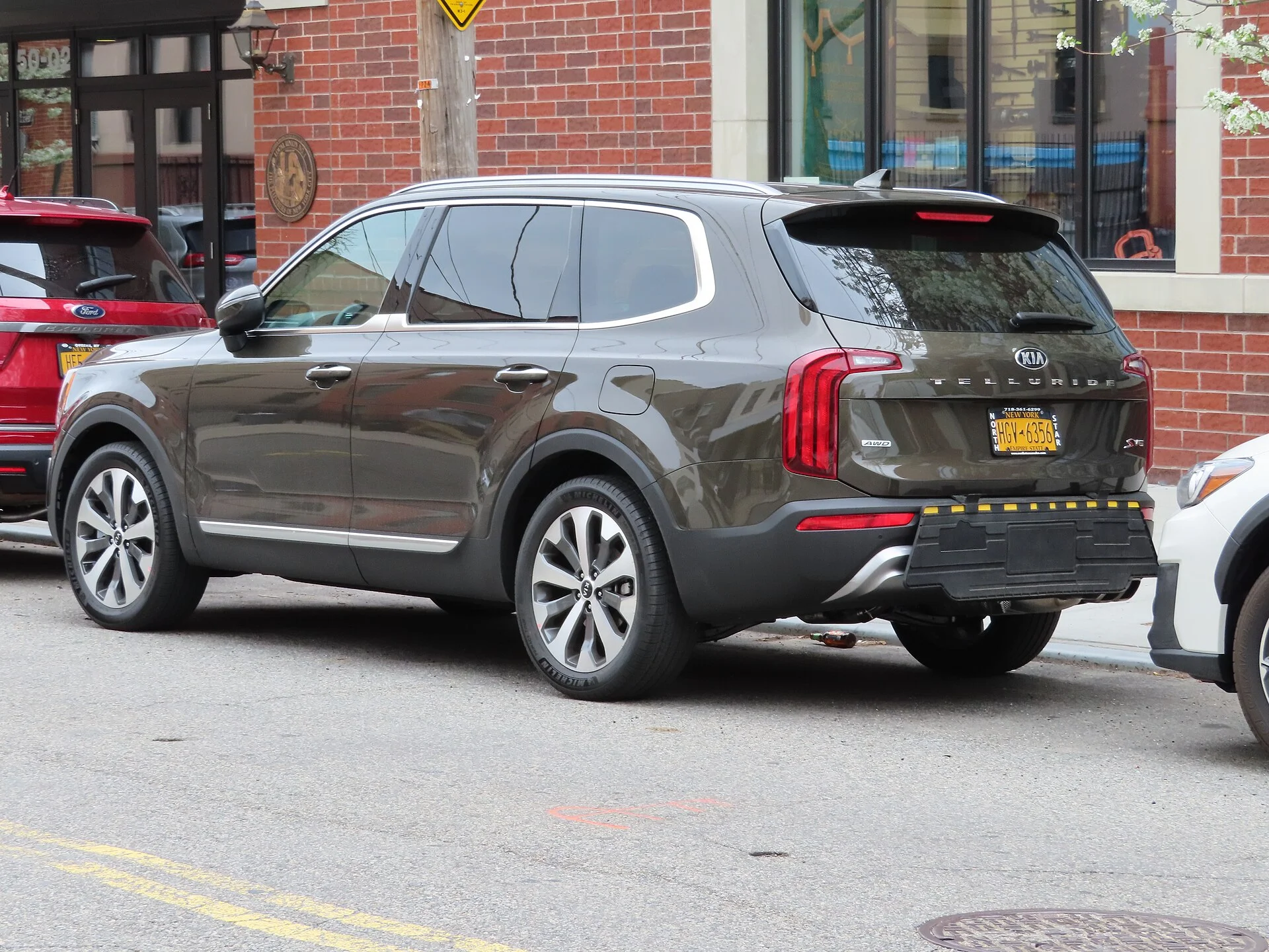 Kia Telluride — an olive-green 2020 Telluride, side three-quarter view with roof rails