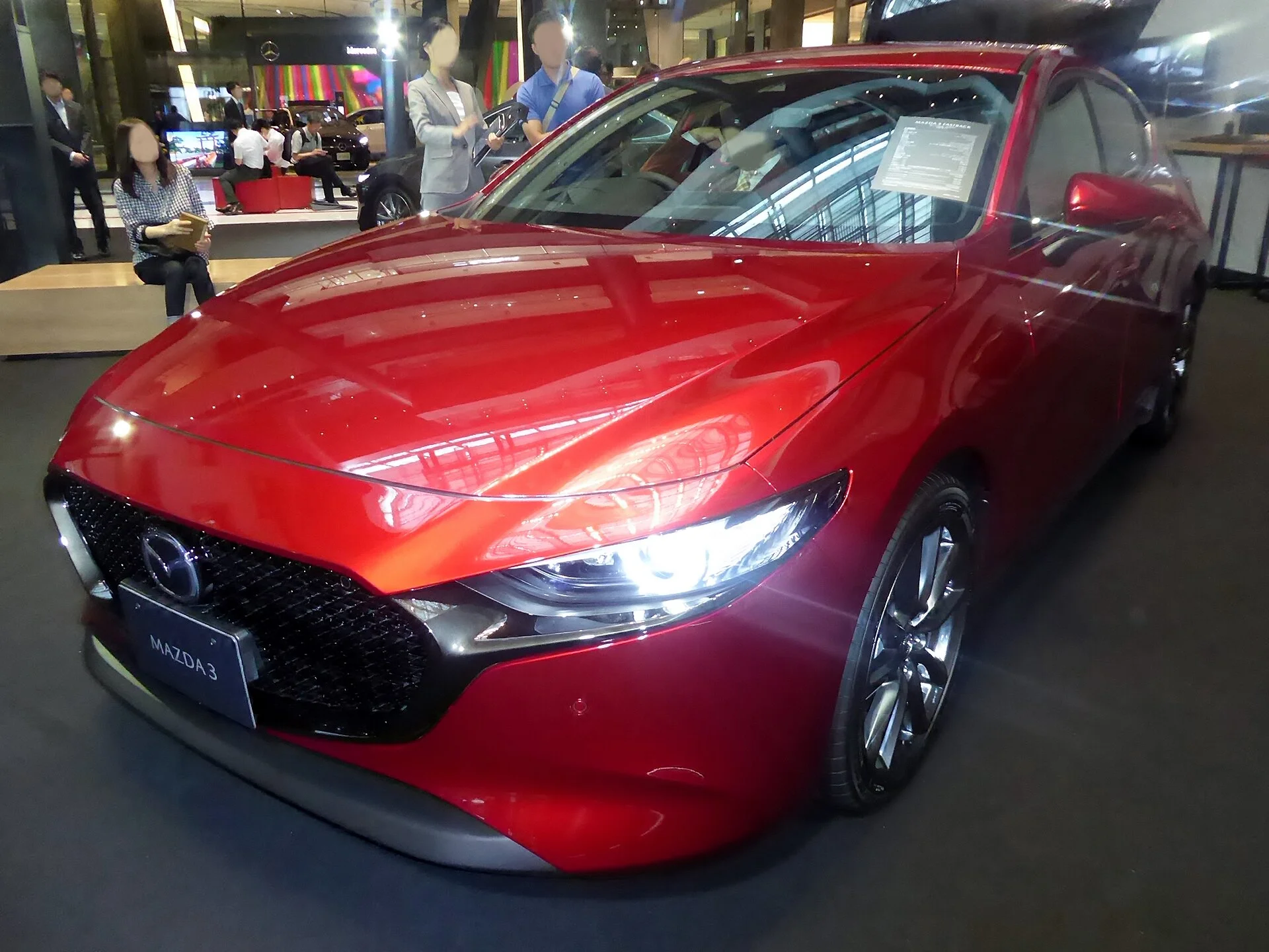 A Mazda 3 hatchback (rear three-quarter view), showing the tailgate and cargo opening relevant to a camping setup.