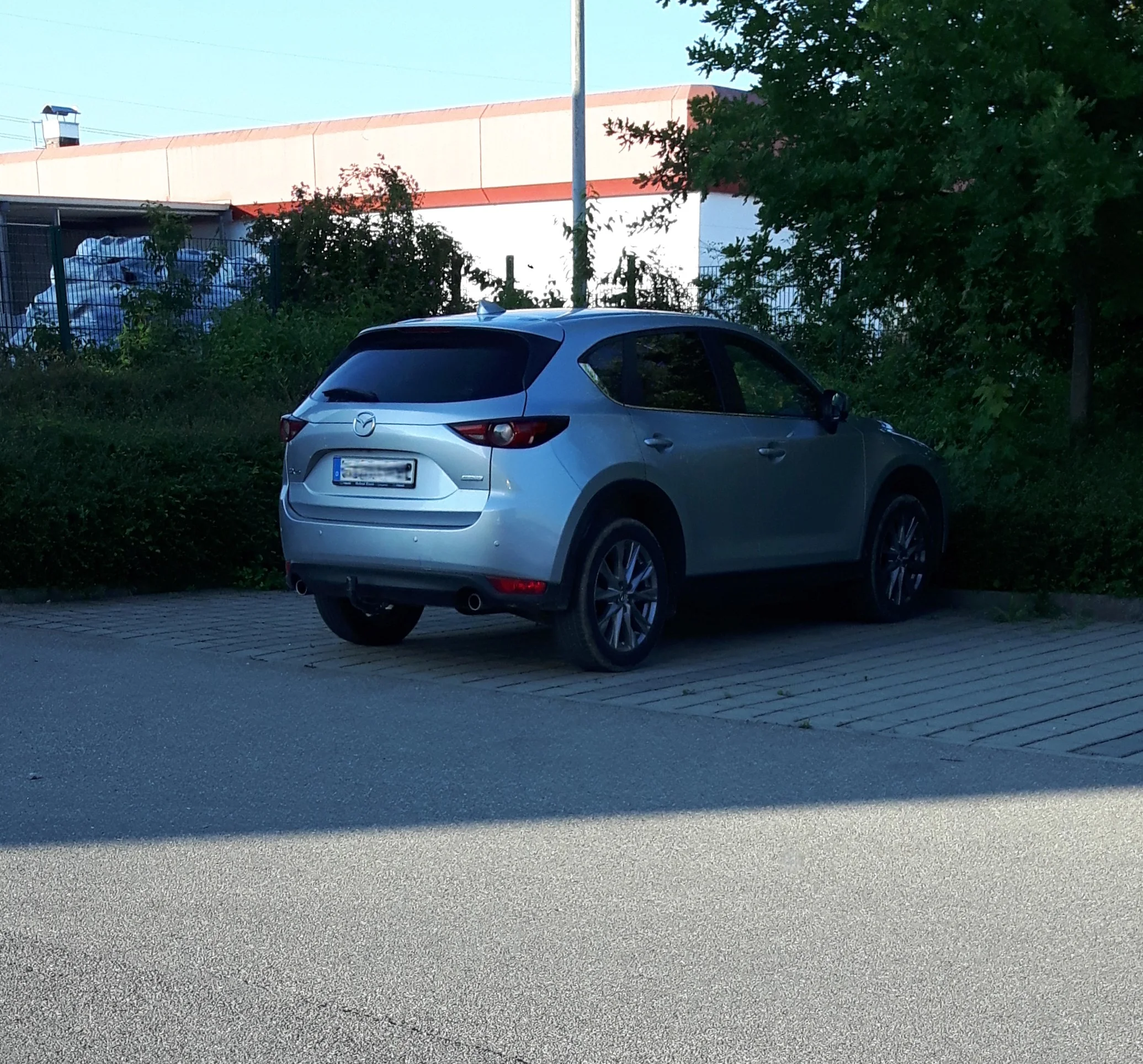 Silver Mazda CX-5 compact SUV, current second generation, rear three-quarter view parked at a kerb.