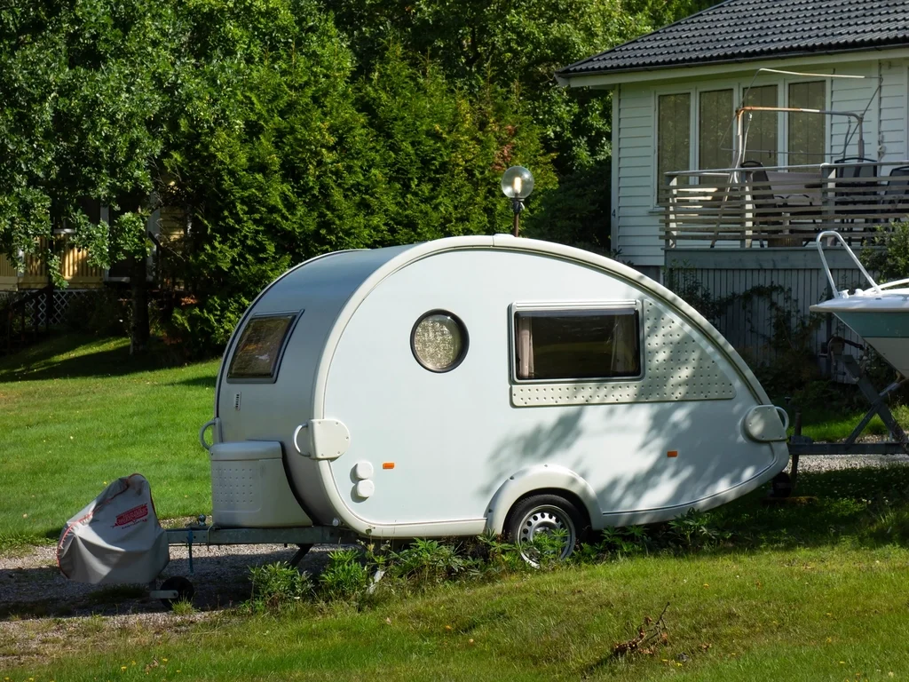 A small teardrop camper trailer, the towed-storage option this guide weighs against a roof box