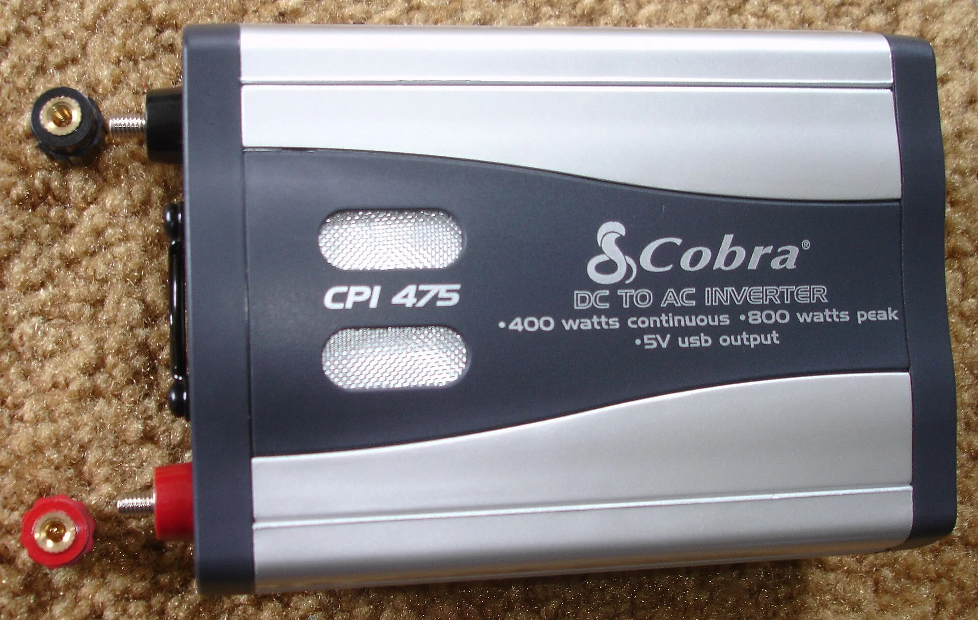 The same Cobra CPI-475 400-watt car power inverter viewed from the top, showing its ventilation grille and branding.