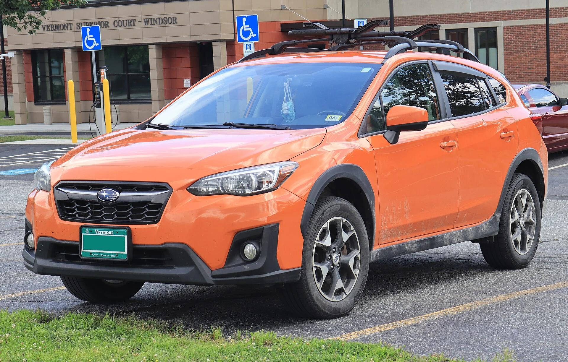 Orange Subaru Crosstrek with roof rails, front three-quarter view