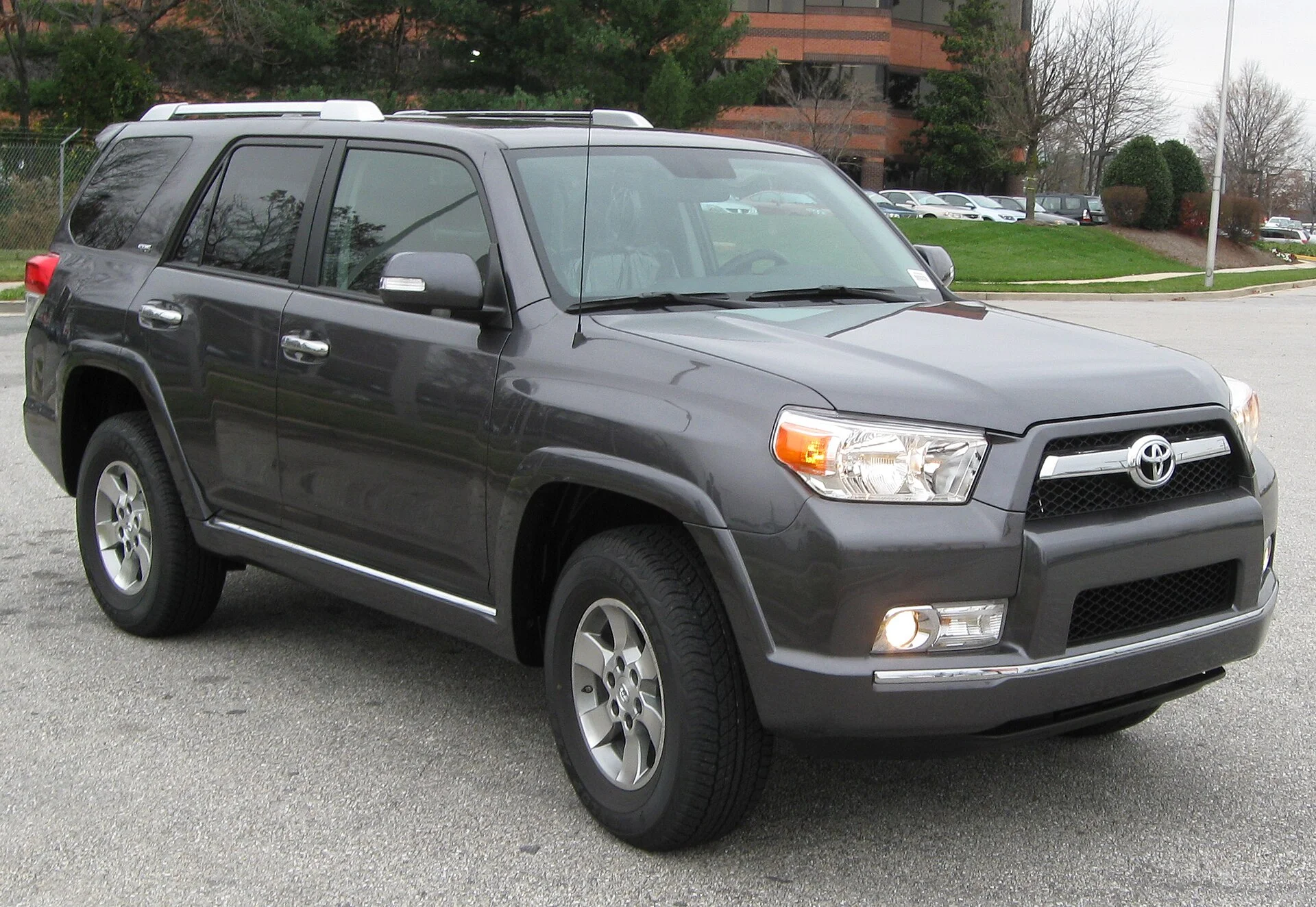 Grey Toyota 4Runner SR5 SUV, front three-quarter view showing the Toyota grille badge, roof rails and fog lamps