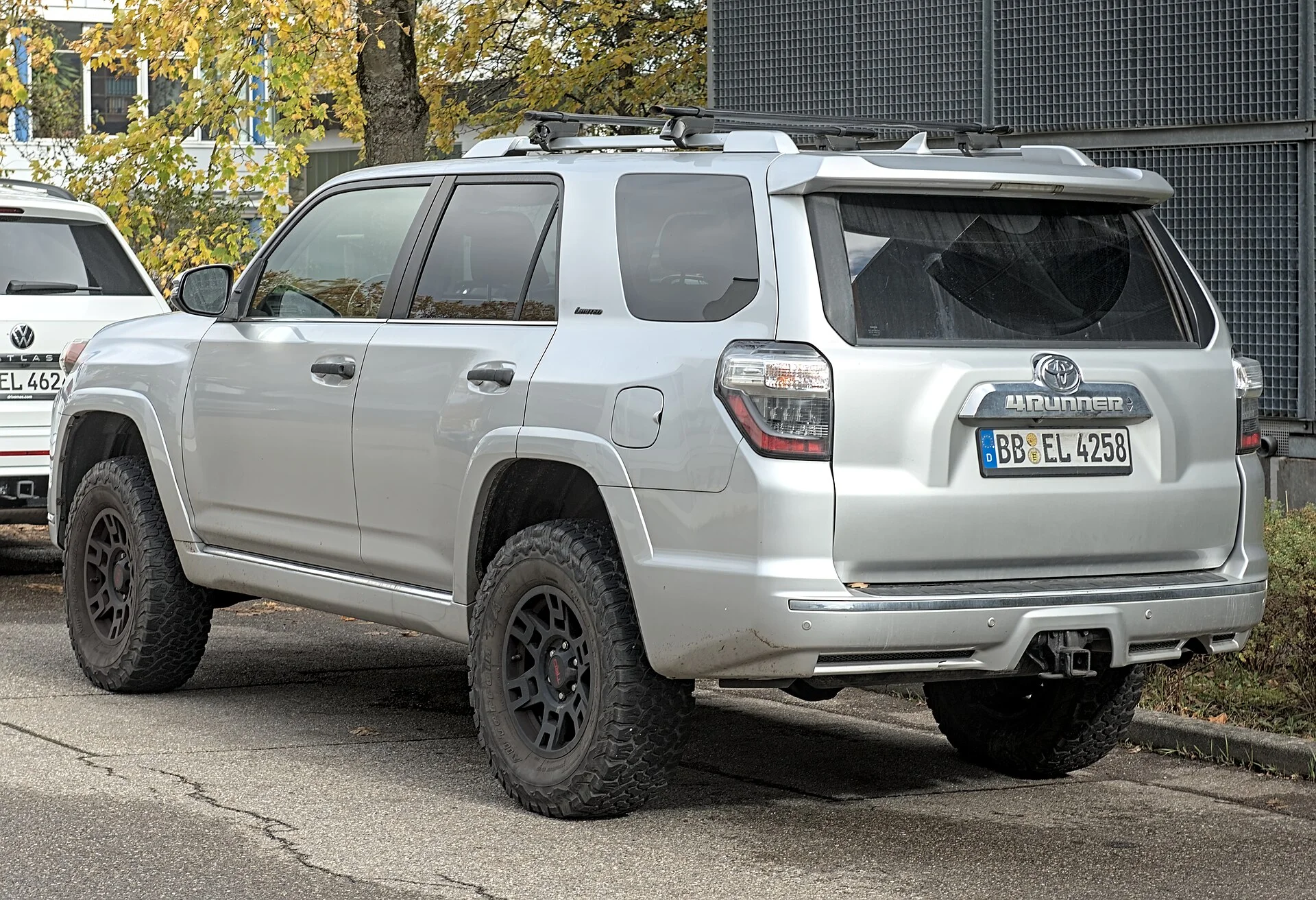 White Toyota 4Runner (fifth generation, N280) with off-road tires, side view on a forest trail