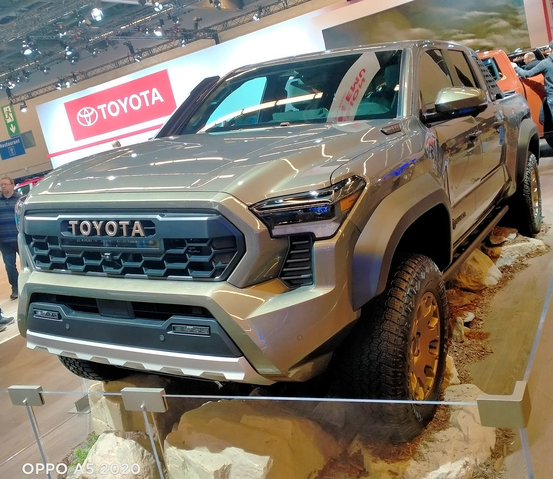 Toyota Tacoma — a 2024 Tacoma displayed on rocks at an auto show
