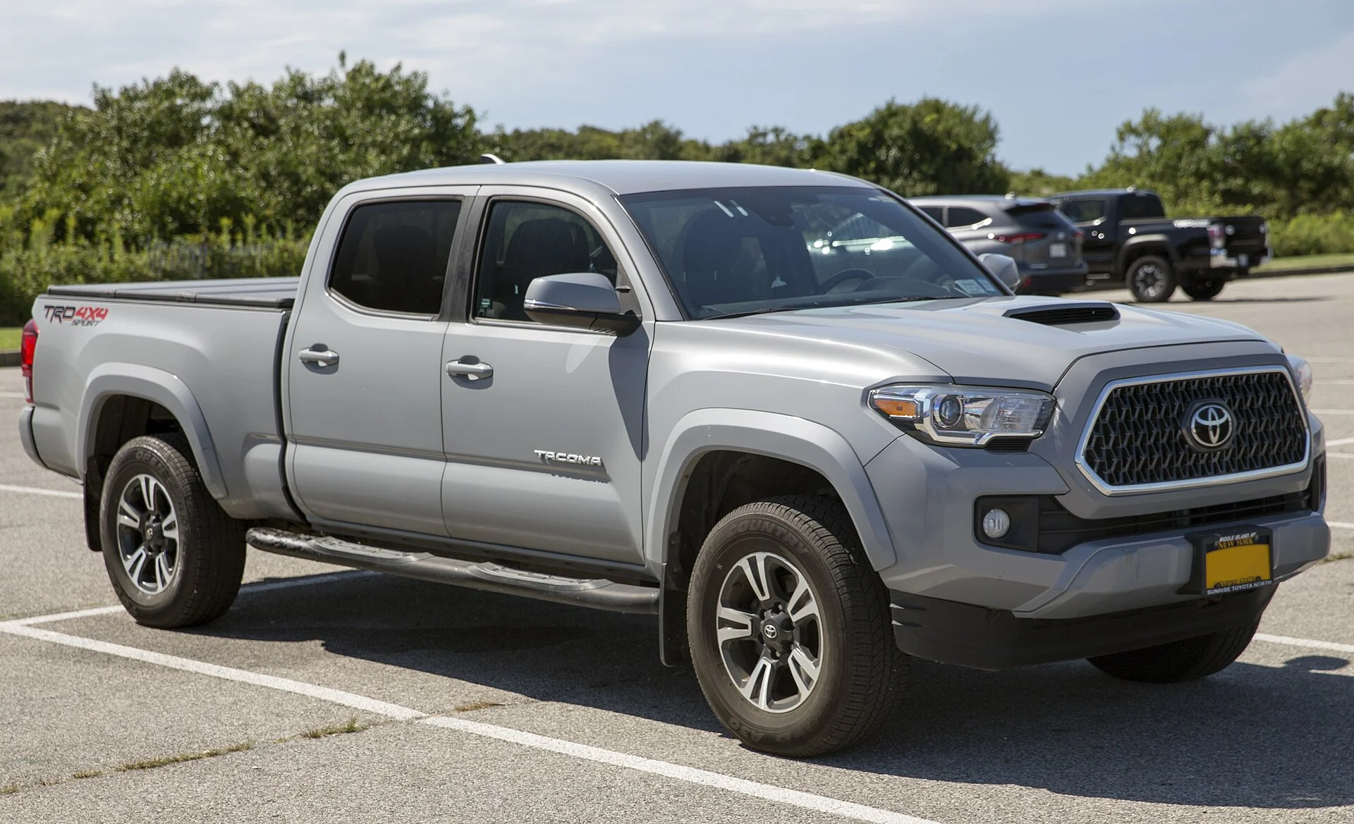 Silver Toyota Tacoma TRD Sport double cab with a long bed, side view (2019)