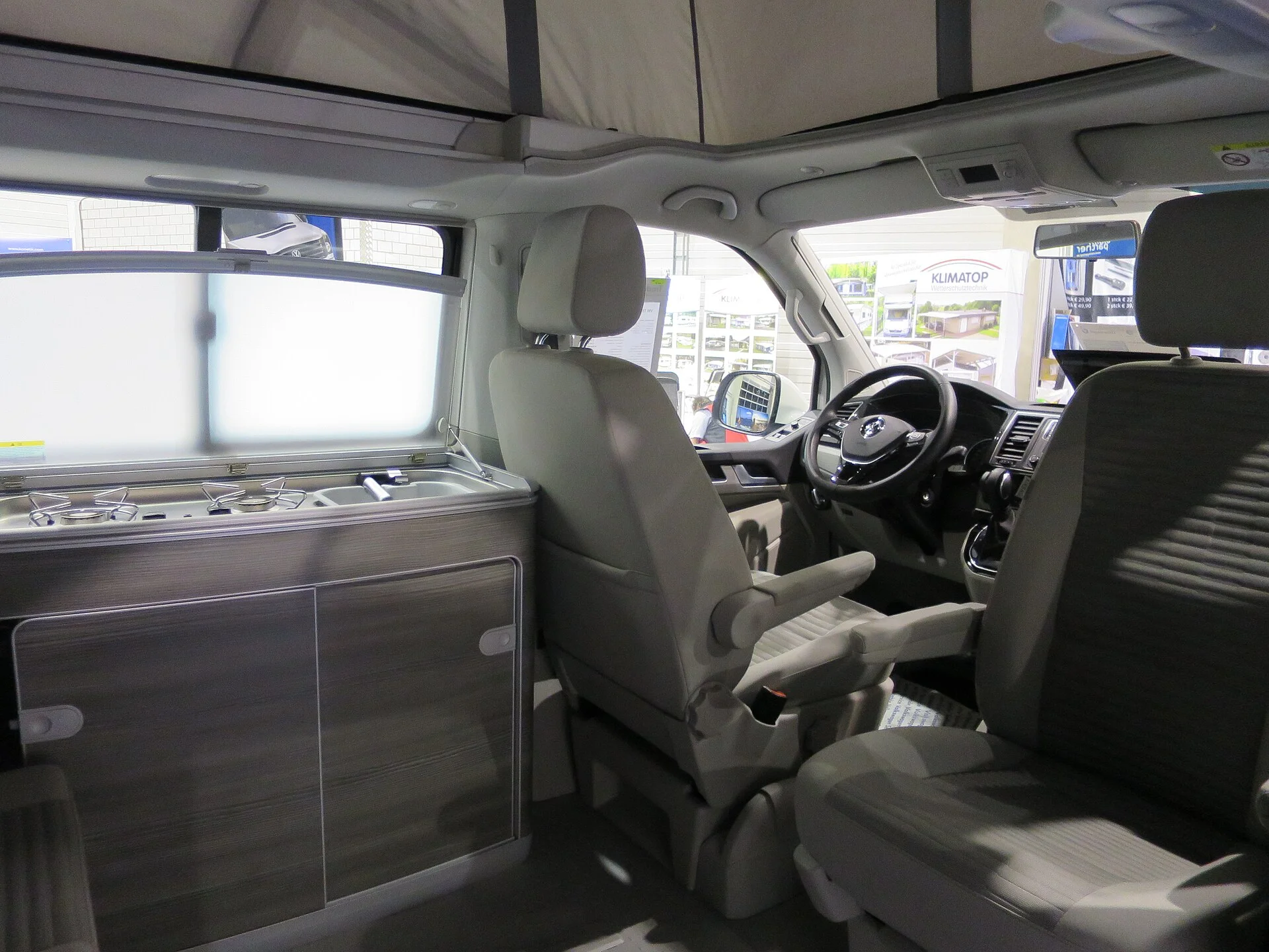 Inside a Volkswagen California, the compact kitchen-and-seating living space of the pop-top camper