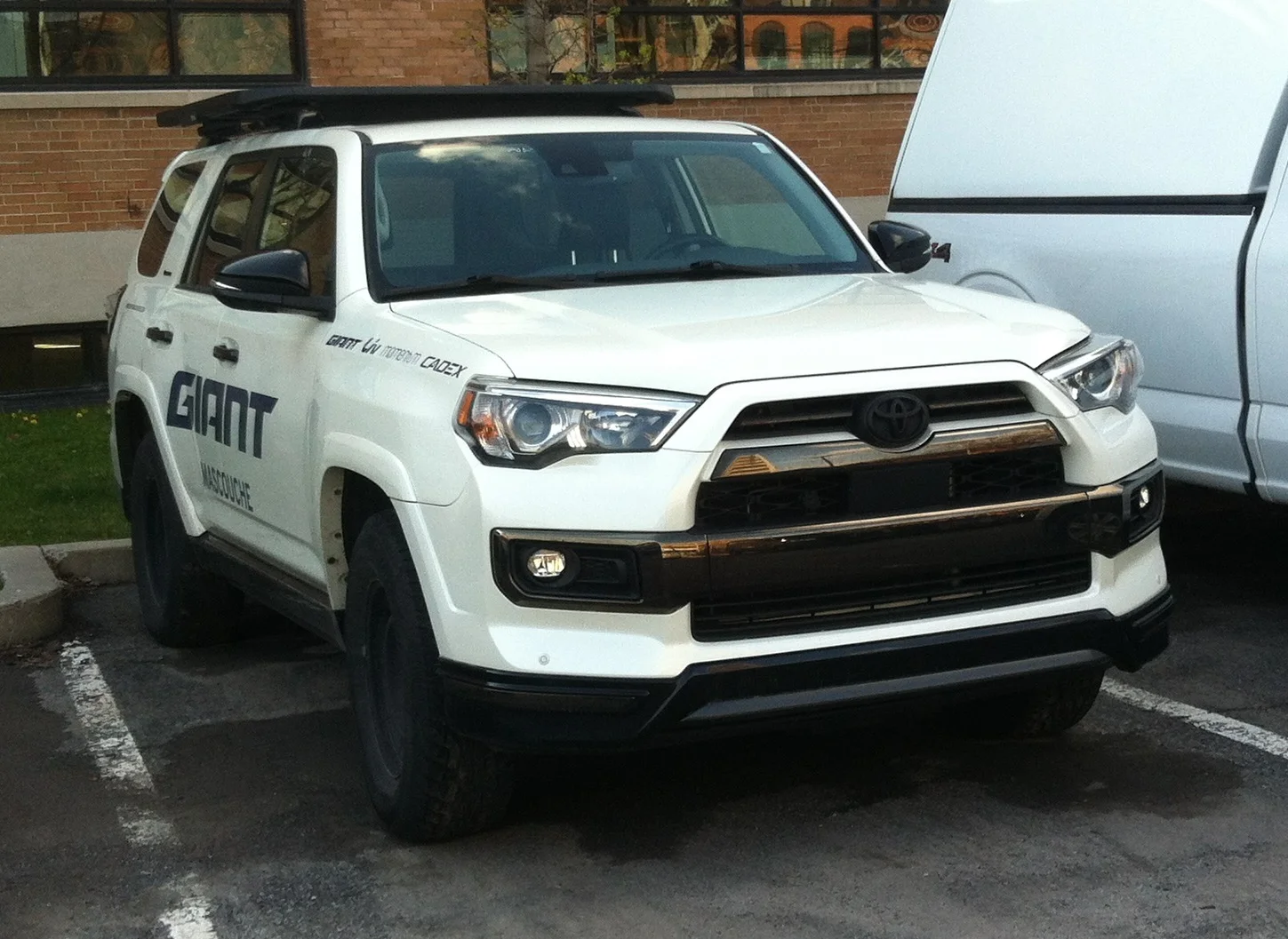 White Toyota 4Runner with a roof rack, front three-quarter view