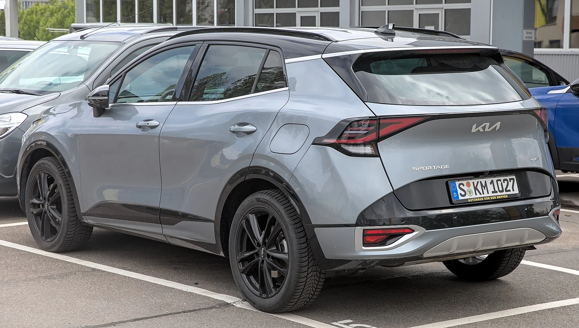 Kia Sportage (NQ5) in grey, rear three-quarter view