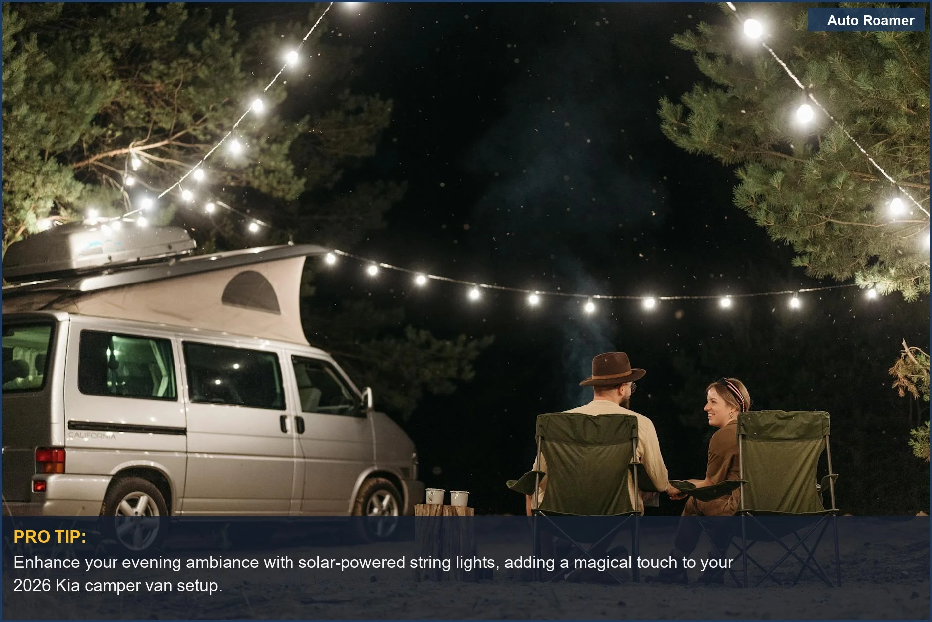 Una pareja disfruta de una noche tranquila bajo luces de cadena junto a su furgoneta camper Kia 2026 en un campamento forestal.