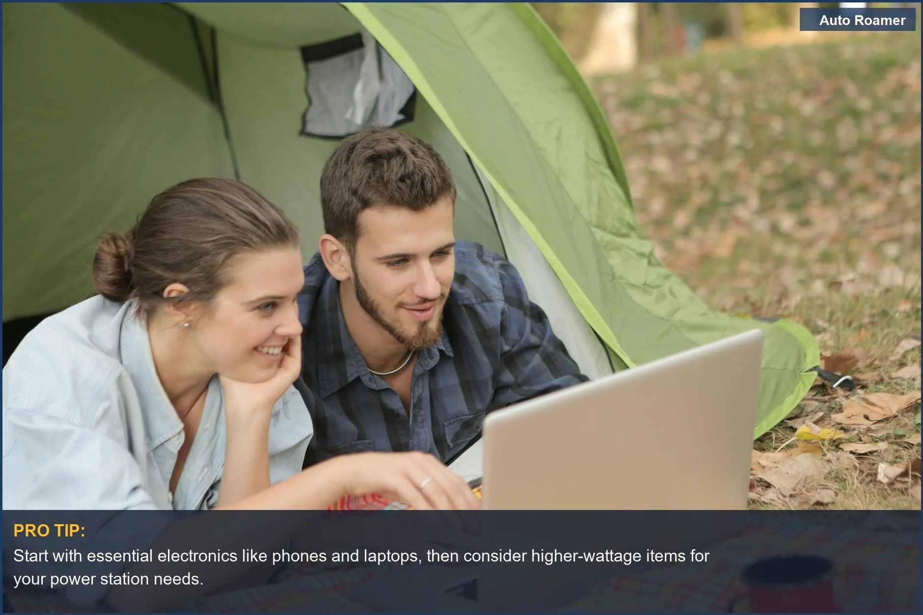 Couple using laptop and charging devices in a tent with a portable power station for car camping electronics.
