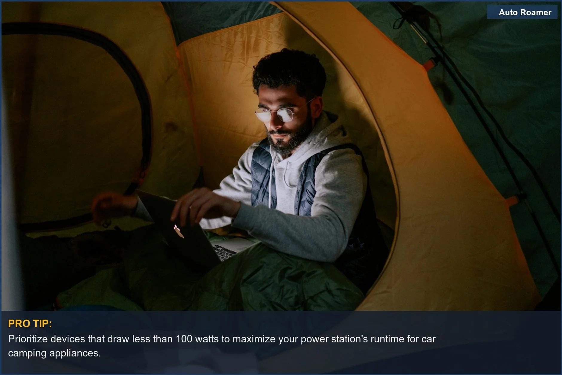 Man working on a laptop inside a tent, demonstrating power station appliances for car camping adventures.