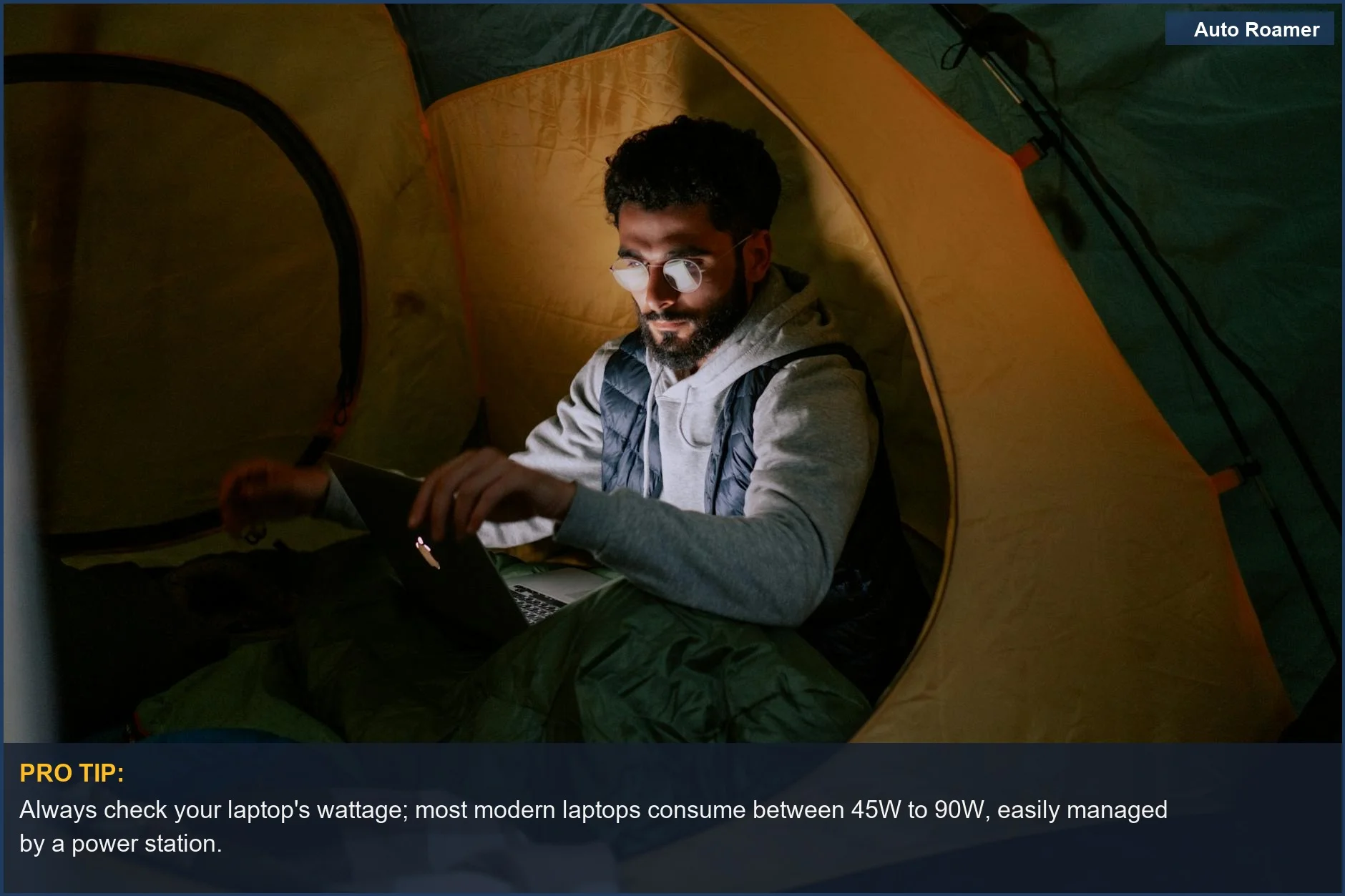 Man working on a laptop inside a tent, illustrating power station appliances for a digital nomad camping lifestyle.