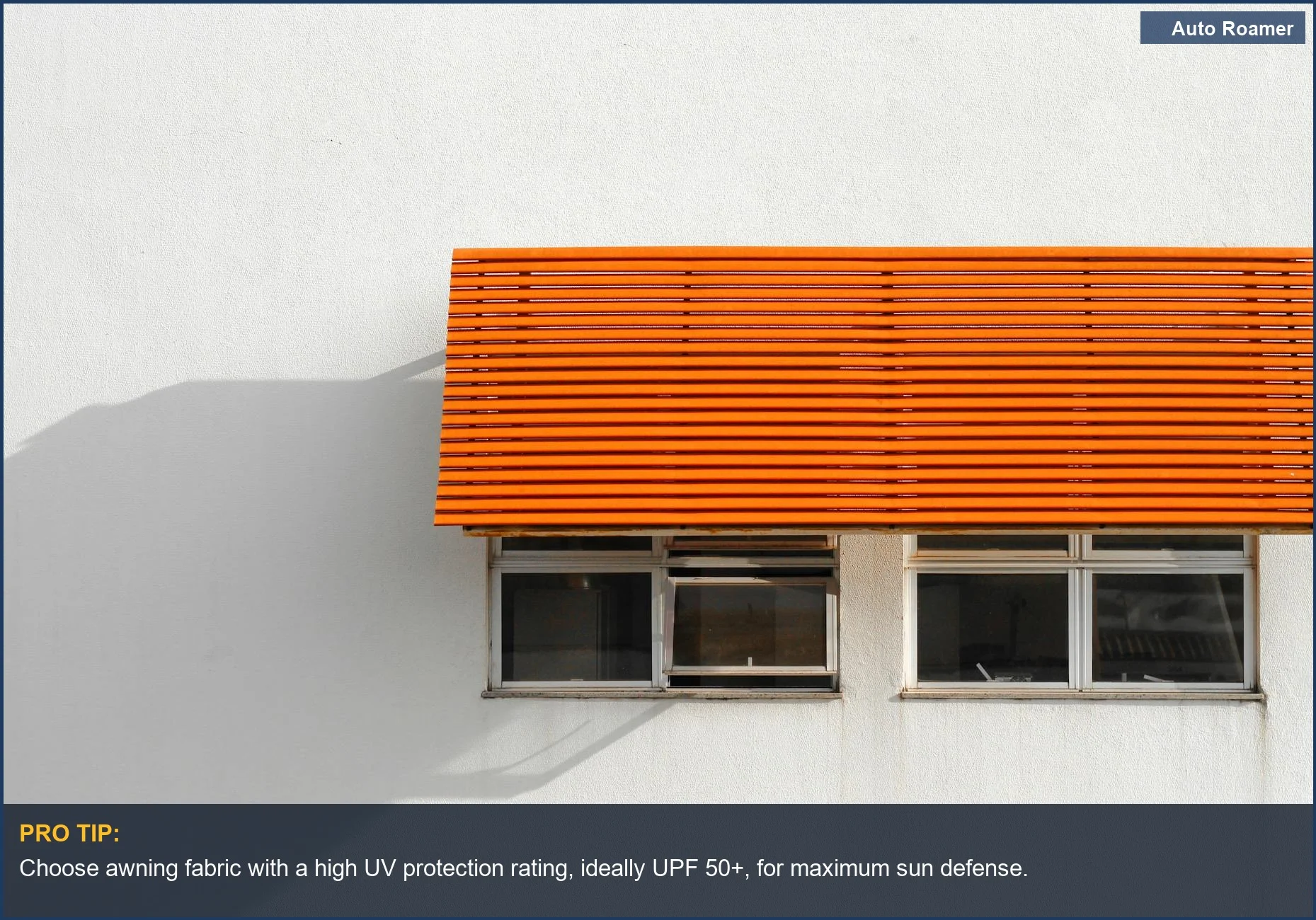Modern orange vehicle awning fabric providing shade against a white building facade.