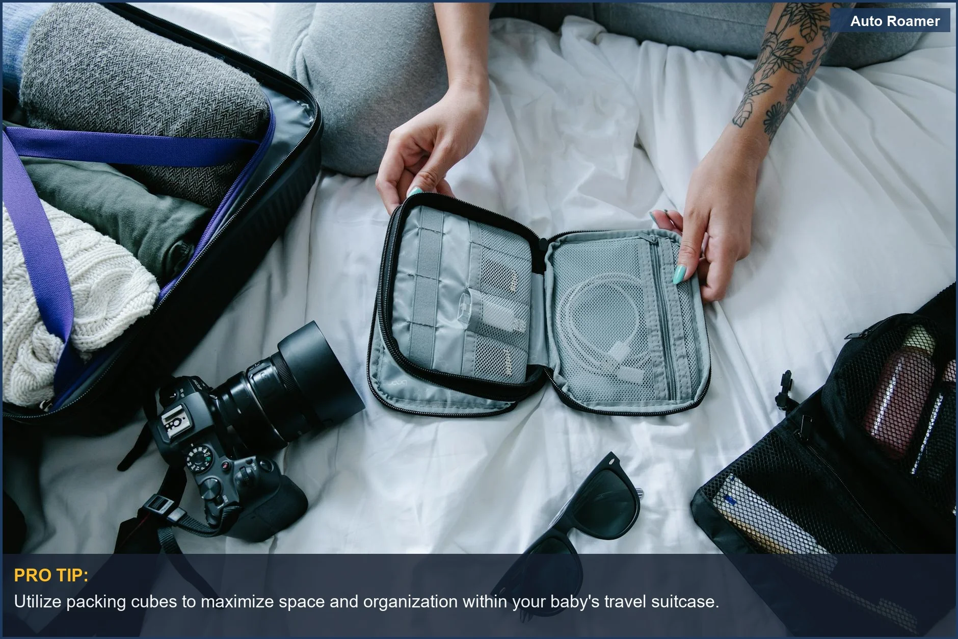 Artículos esenciales de viaje organizados en una cama de hotel, incluyendo cubos de embalaje para la maleta del bebé.