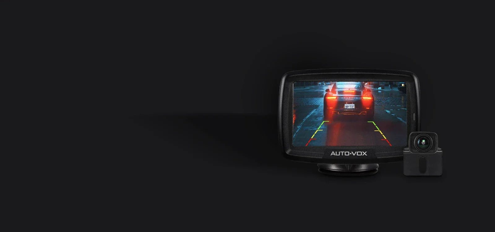 Backup camera monitor showing fixed rear guide lines over a night reversing view