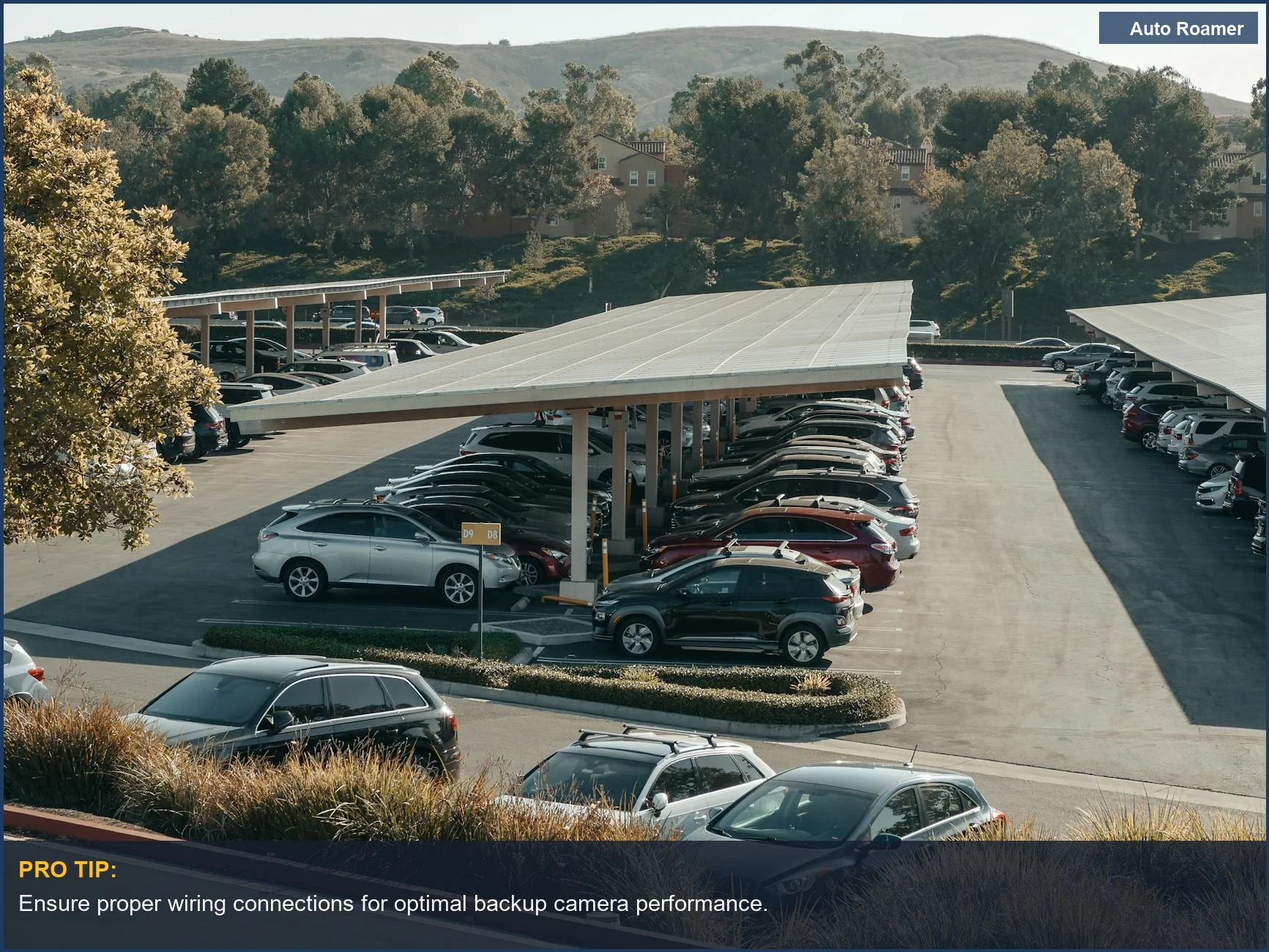 Large parking lot with solar panels and multiple vehicles, highlighting safety in backup camera installation.