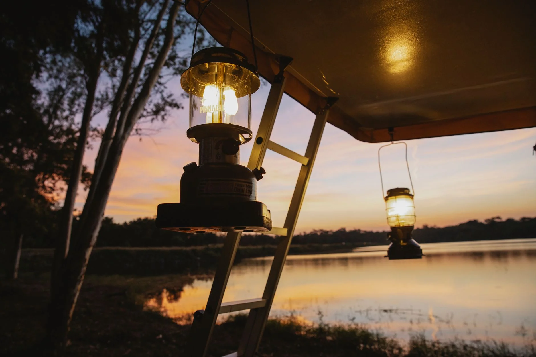 A camping lantern lighting a campsite in the evening, the high-output use that draws the most battery power.