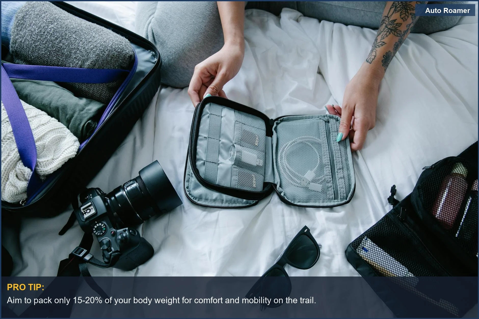 Organized travel packing cubes and camera on a bed, essential for preventing overpacking for first time camping.