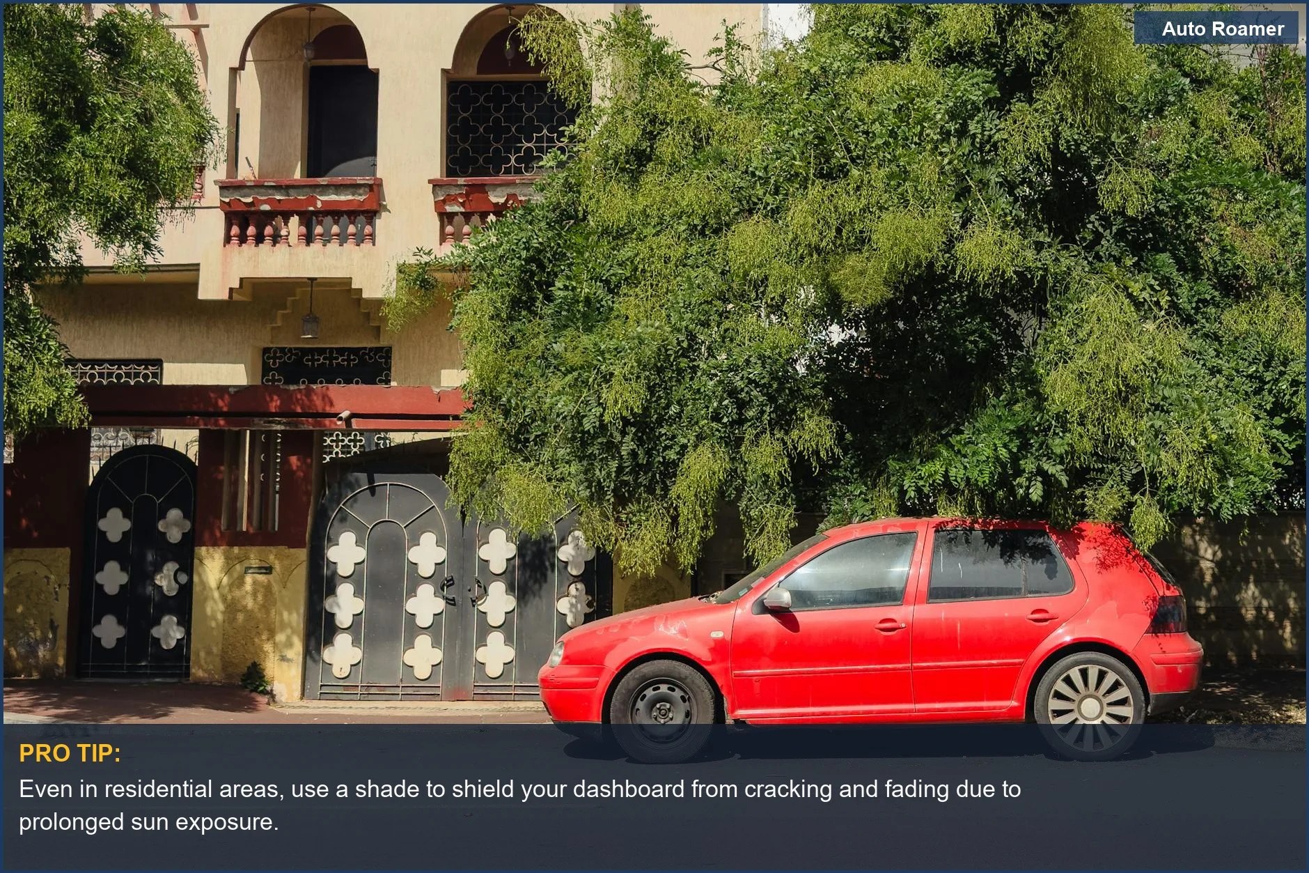 Bright red car in residential shade, highlighting windshield protection from intense sun.