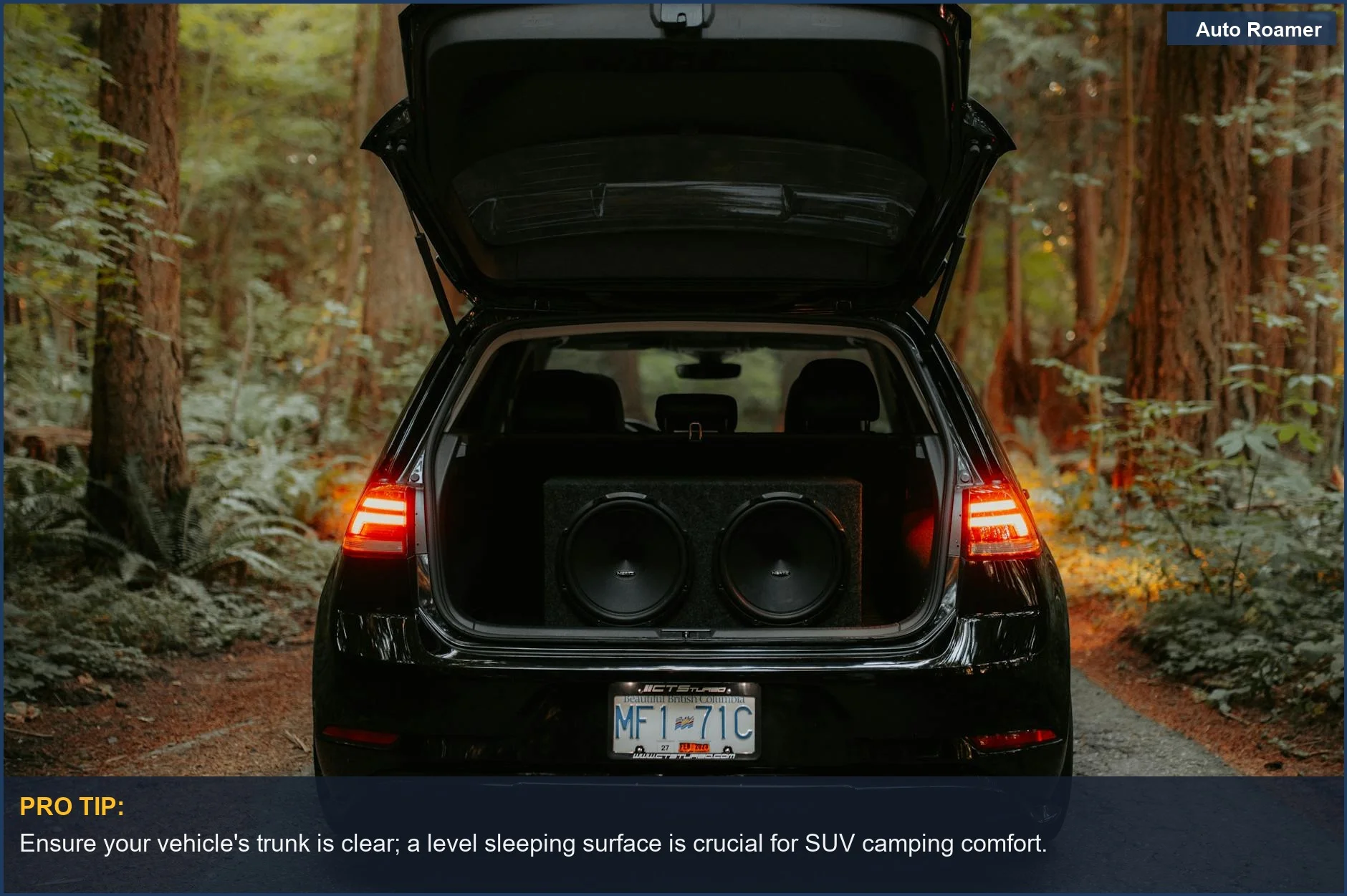 Car parked in a forest with trunk open, revealing sound system, not ideal for sleeping.