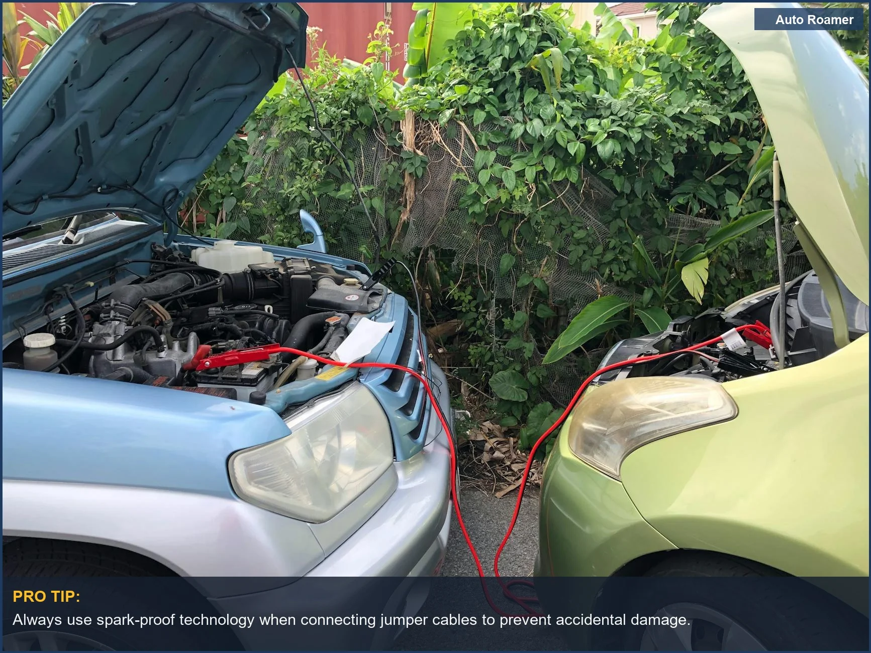 Two cars linked with jumper cables, demonstrating an emergency battery charge solution.