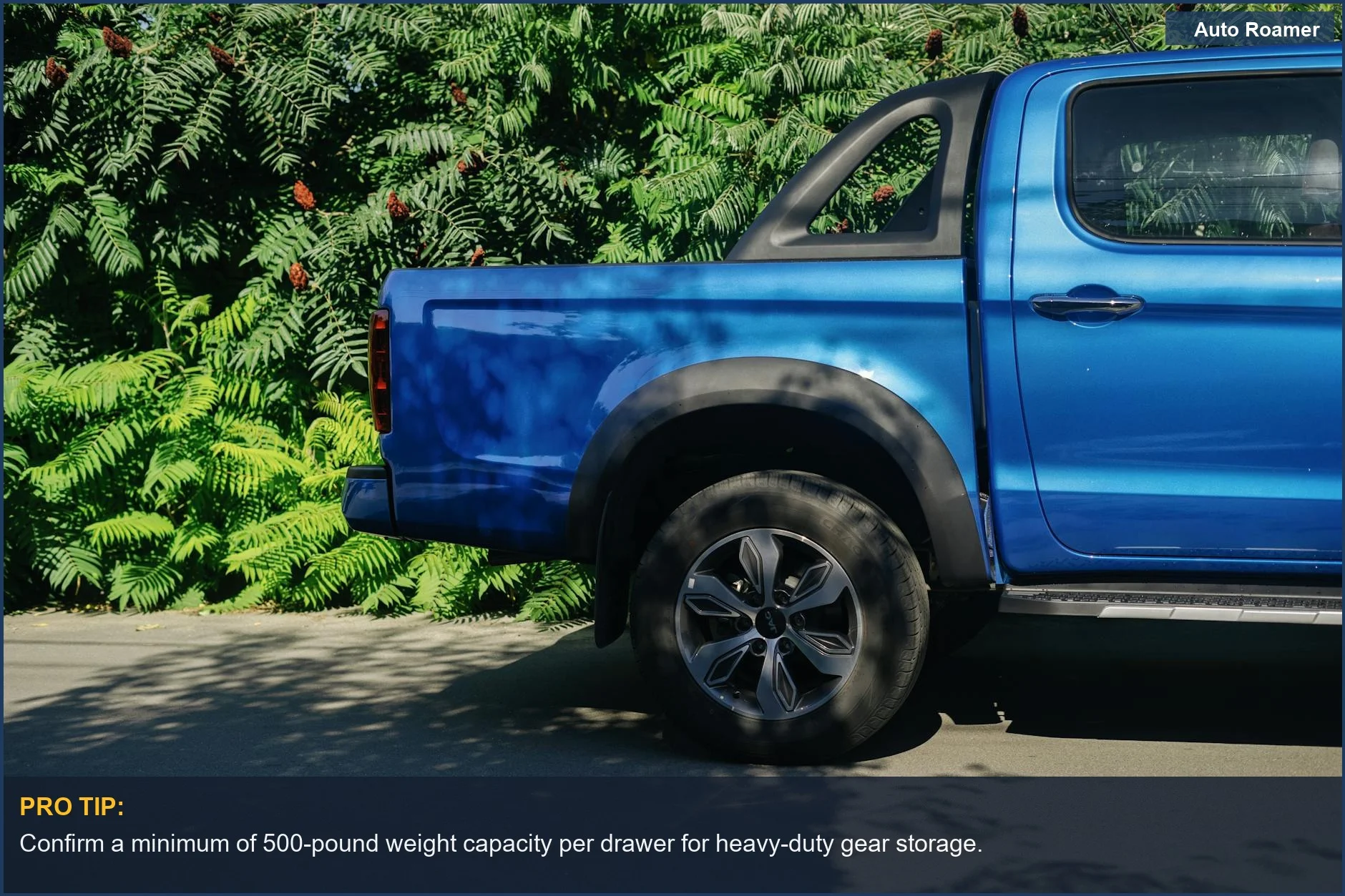 Side view of a blue pickup truck against lush foliage, symbolizing the ideal setup for a car camping drawer system.