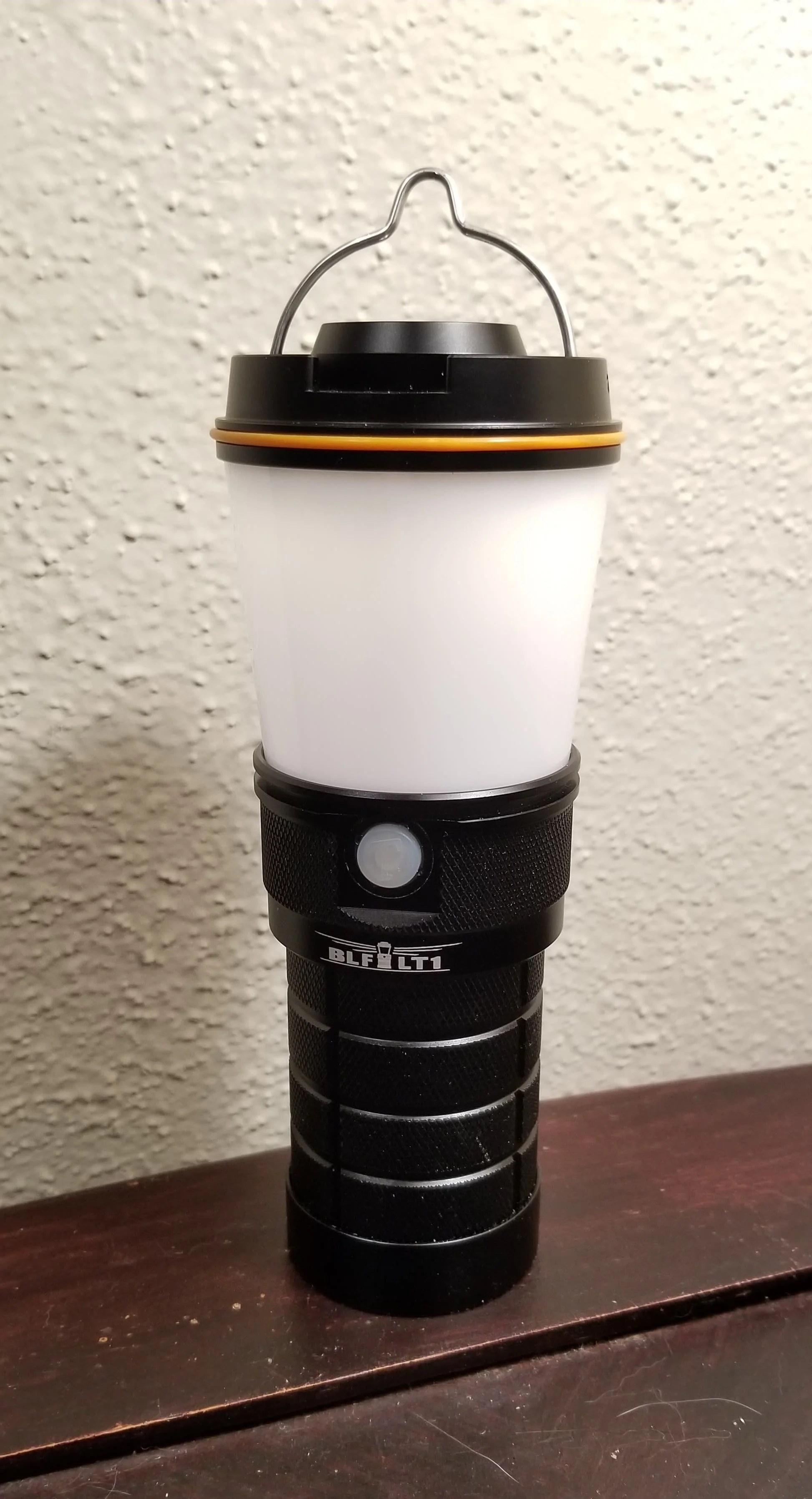 A cylindrical rechargeable LED camping lantern standing on a wooden surface, the type of runtime-focused lantern this guide evaluates.