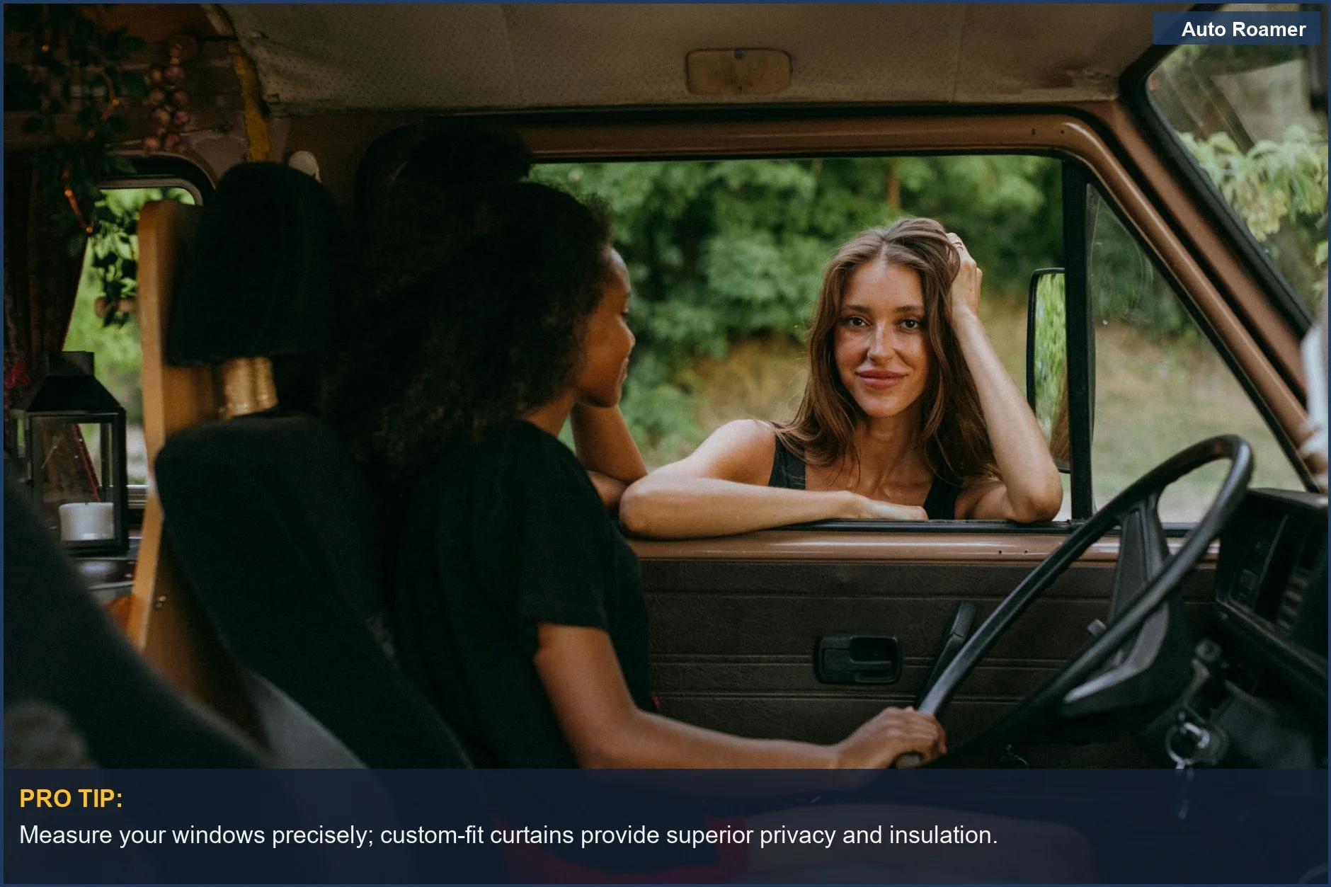Two women in lush landscape inside camper van, enjoying road trip privacy.